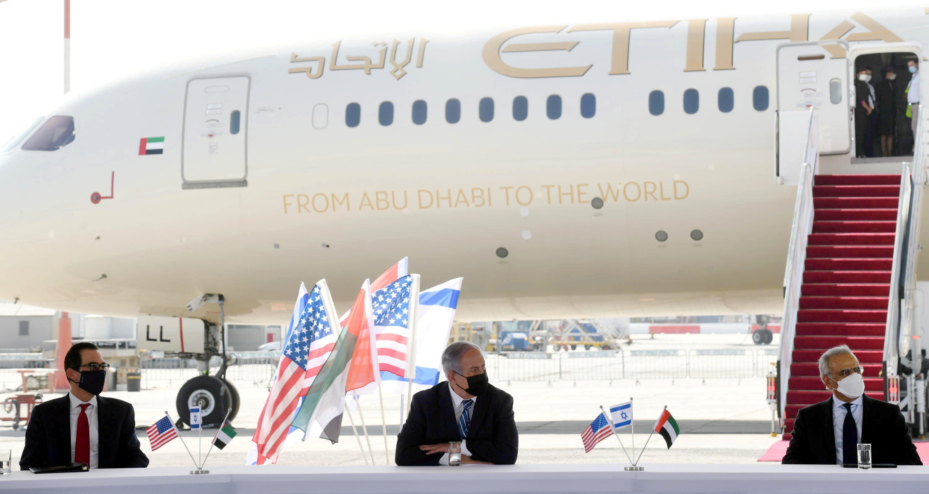  El primer ministro israelí Benjamin Netanyahu, el secretario del Tesoro de los Estados Unidos Steve Mnuchin y el Ministro de Estado de los Emiratos Árabes Unidos Obaid Humaid al-Tayer, en el aeropuerto Ben Gurion, cerca de Tel Aviv (WAM/Handout via REUTERS)