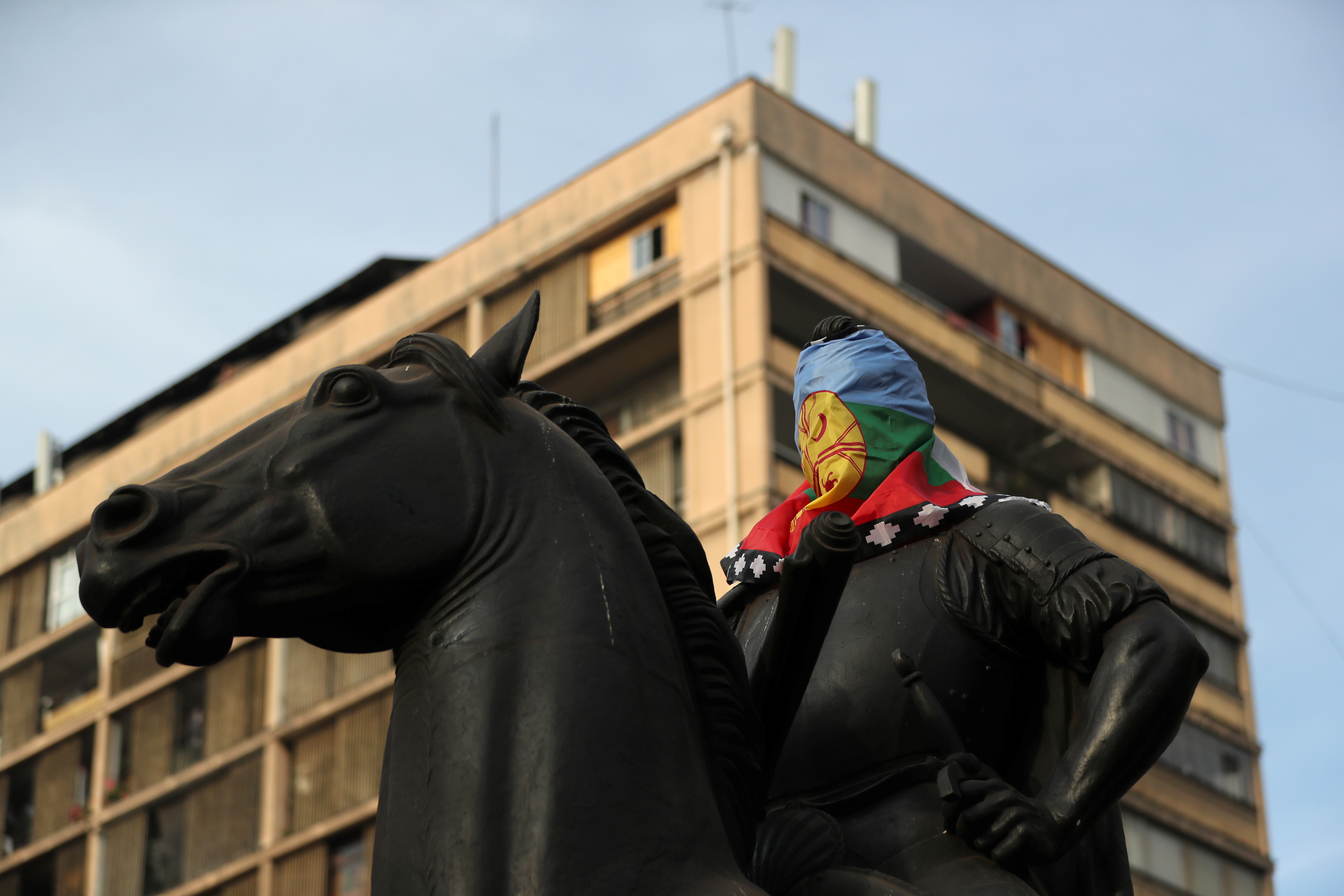 La cabeza de la estatua del conquistador español Pedro de Valdivia está cubierta con una bandera mapuche en Santiago, Chile (REUTERS/Ivan Alvarado)