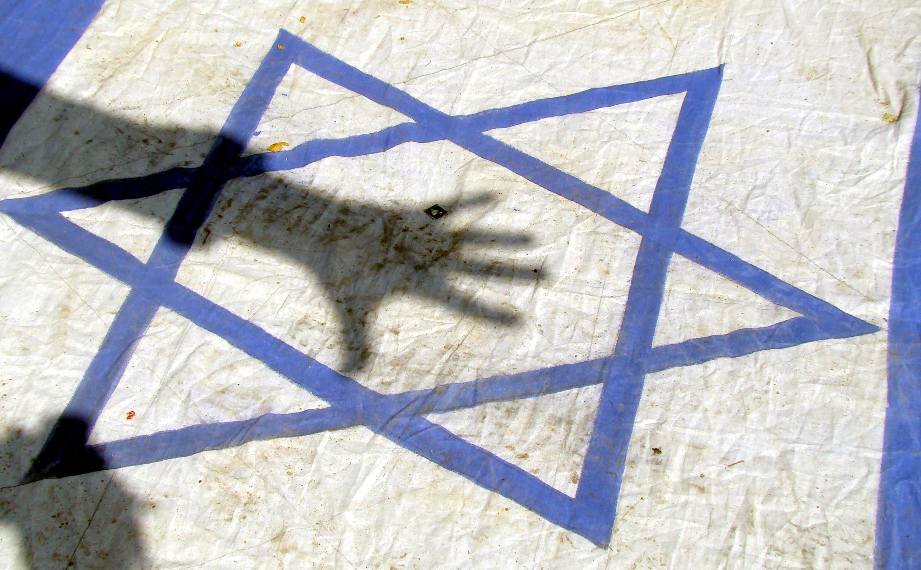 La sombra de una mano proyectada sobre una bandera Israel (Foto: EFE/Nadeem Khawer/Archivo)
