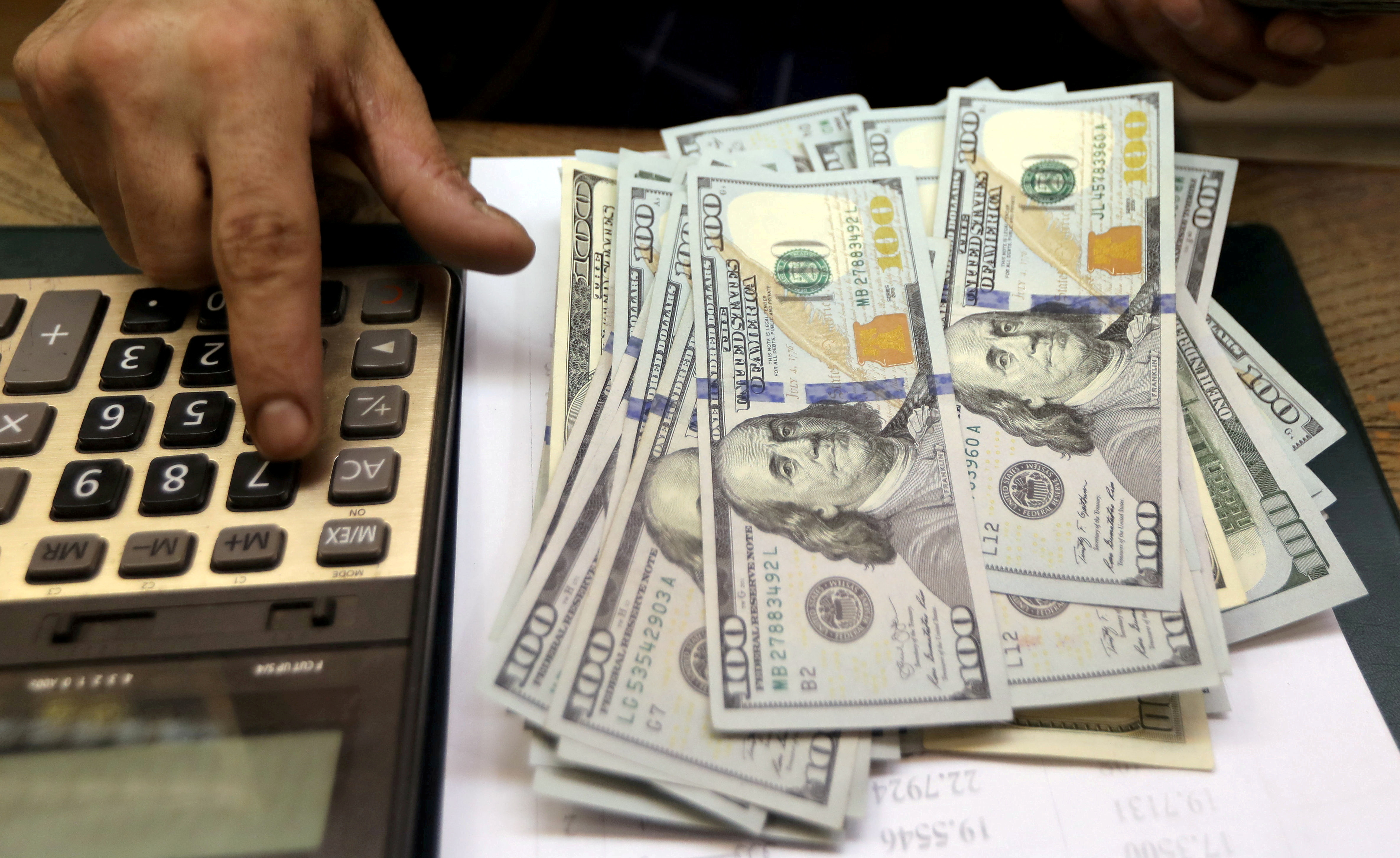 FILE PHOTO: An employee counts U.S. dollar bills at a money exchange office in central Cairo