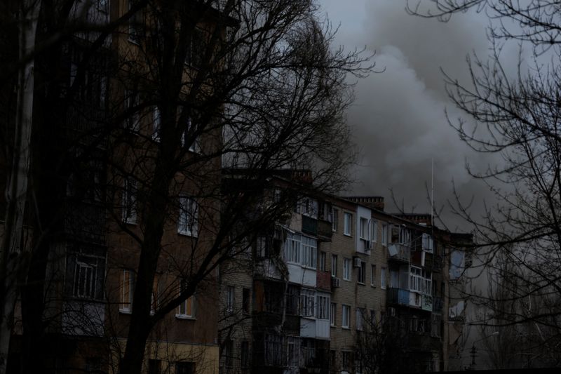 El humo se eleva desde los edificios de apartamentos dañados por los ataques con misiles, mientras continúa el ataque de Rusia contra Ucrania, durante un intenso bombardeo el día de Navidad en la línea del frente en Bajmut, Ucrania
