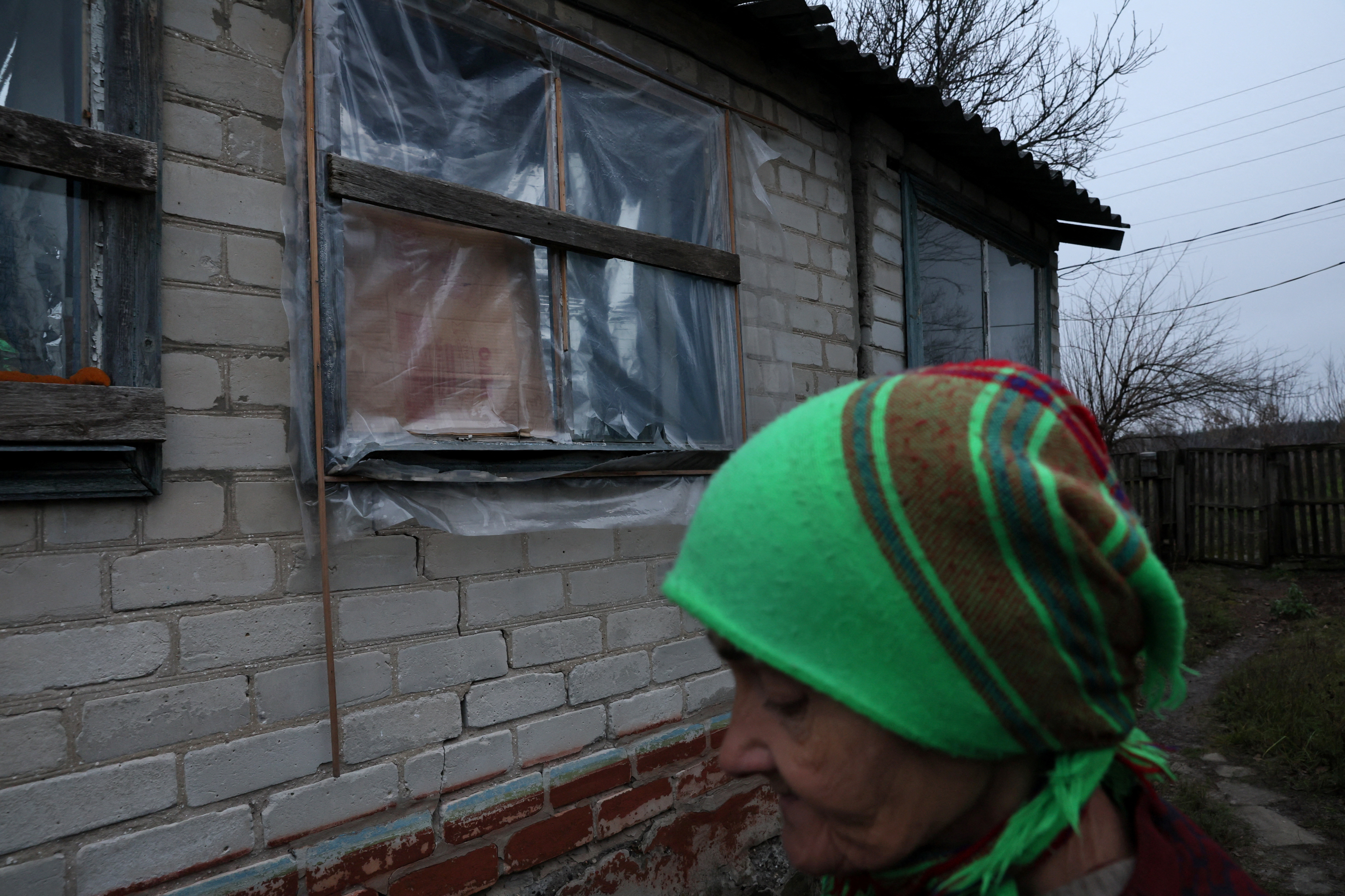 Olena Oleksenko, 73, has been without electricity for months.  She covers her house with plastics and insulating materials in Drobysheve (Reuters)