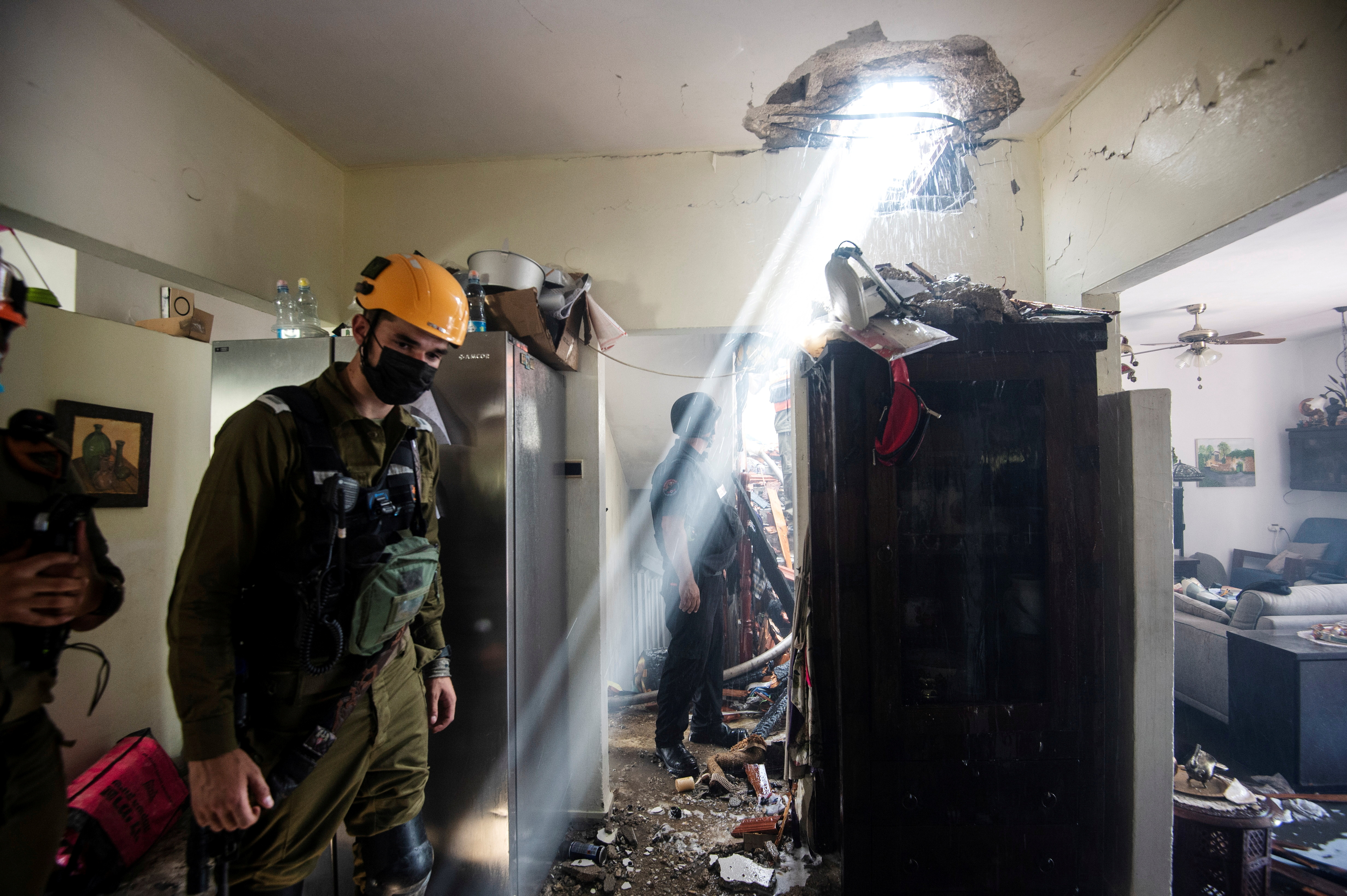 Soldados trabajan en un edificio dañado por un cohete lanzado desde la Franja de Gaza en Ashdod, sur de Israel (REUTERS/Avi Roccah)