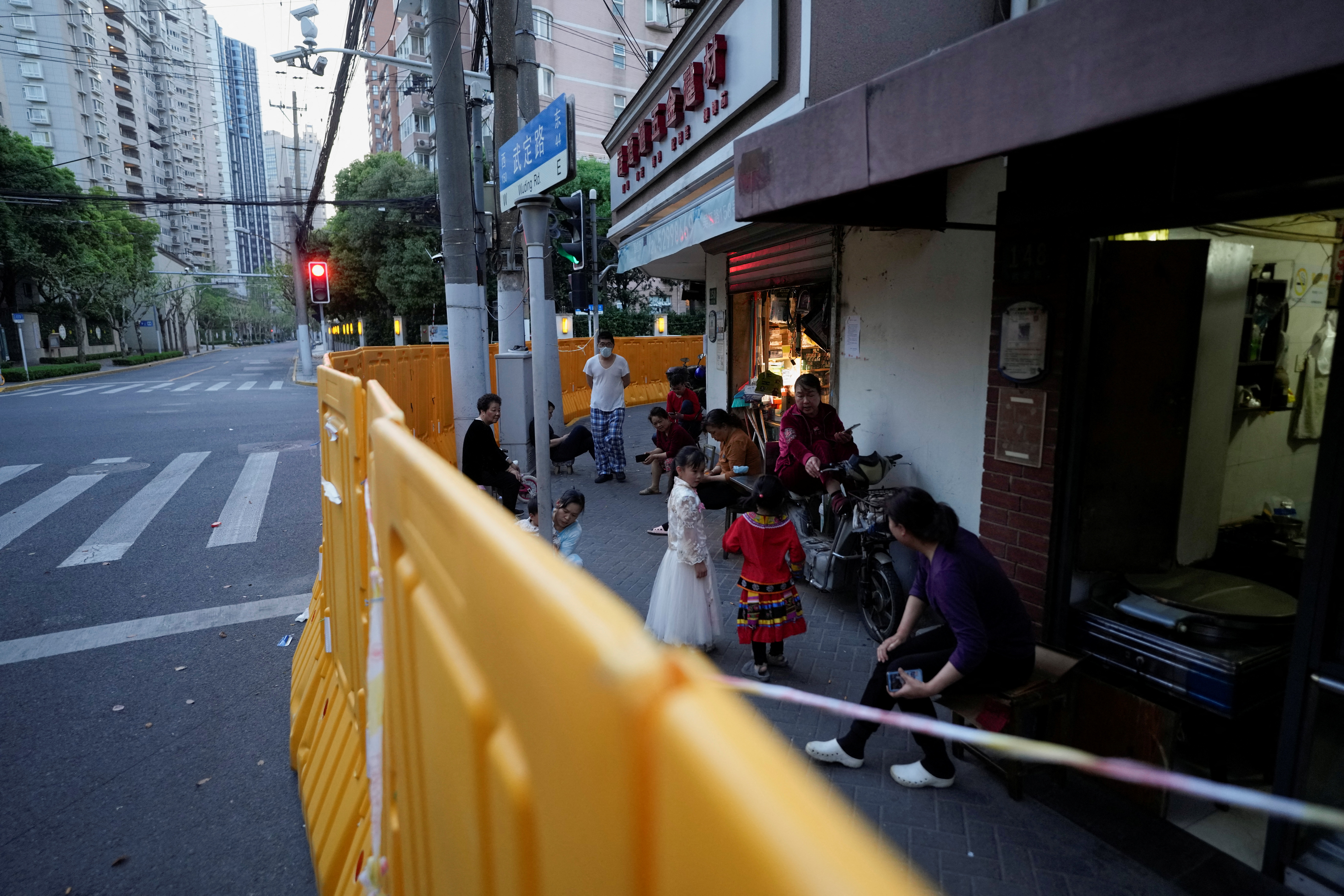 Los residentes se paran detrás de las barricadas colocadas alrededor de un área cerrada, durante un cierre para frenar la propagación de la enfermedad por coronavirus (COVID-19).  REUTERS/Canción de Aly