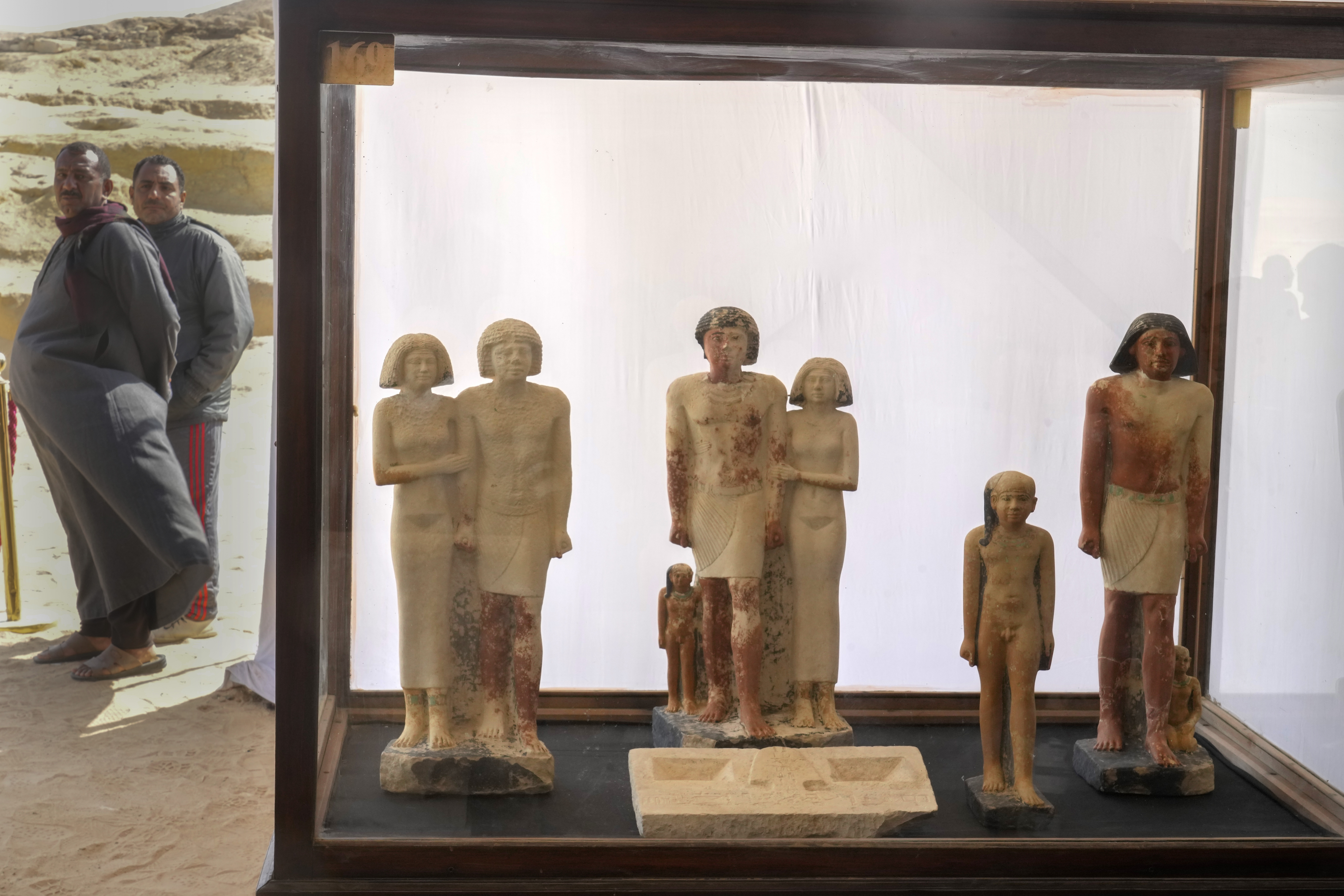 Egyptian antiquities guards stand behind discovered artifacts (AP Photo/Amr Nabil)