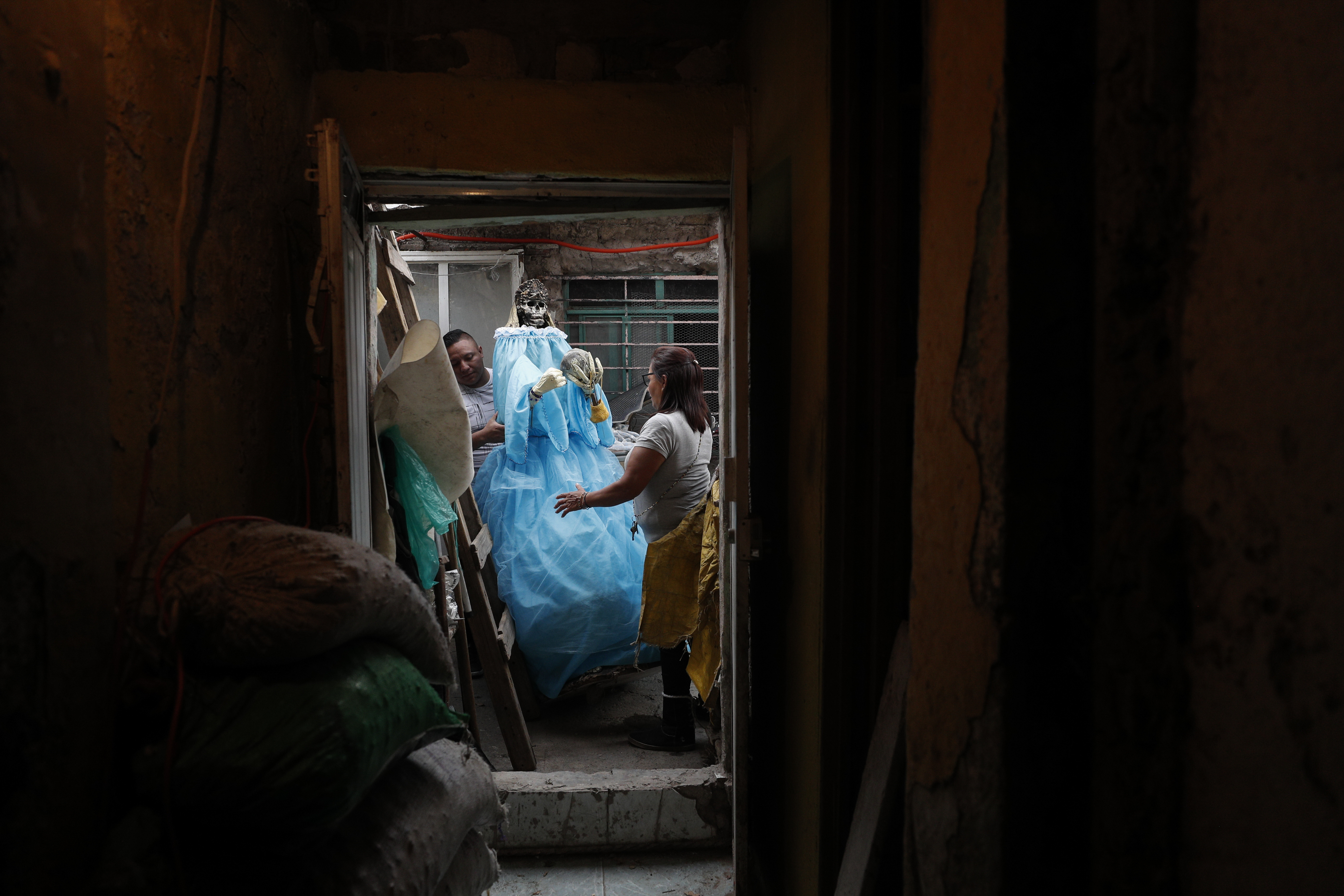 Elvia Sánchez Díaz, de 55 años, recibe ayuda de un vecino para devolver una figura gigante de Santa Muerte a su casa. (Foto: AP / Rebecca Blackwell )