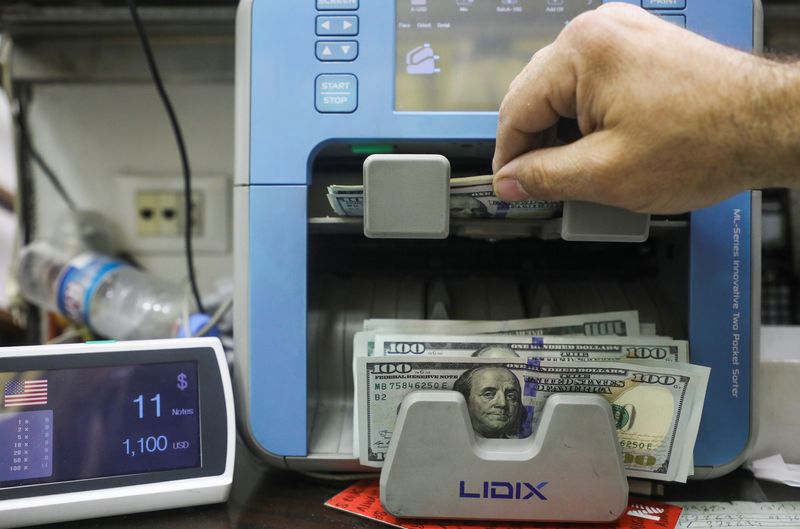 FOTO DE ARCHIVO: Un hombre cuenta billetes de dólares estadounidenses en una tienda de cambio en Beirut, Líbano el 18 de marzo de 2022. REUTERS/Mohamed Azakir/Foto de Archivo
