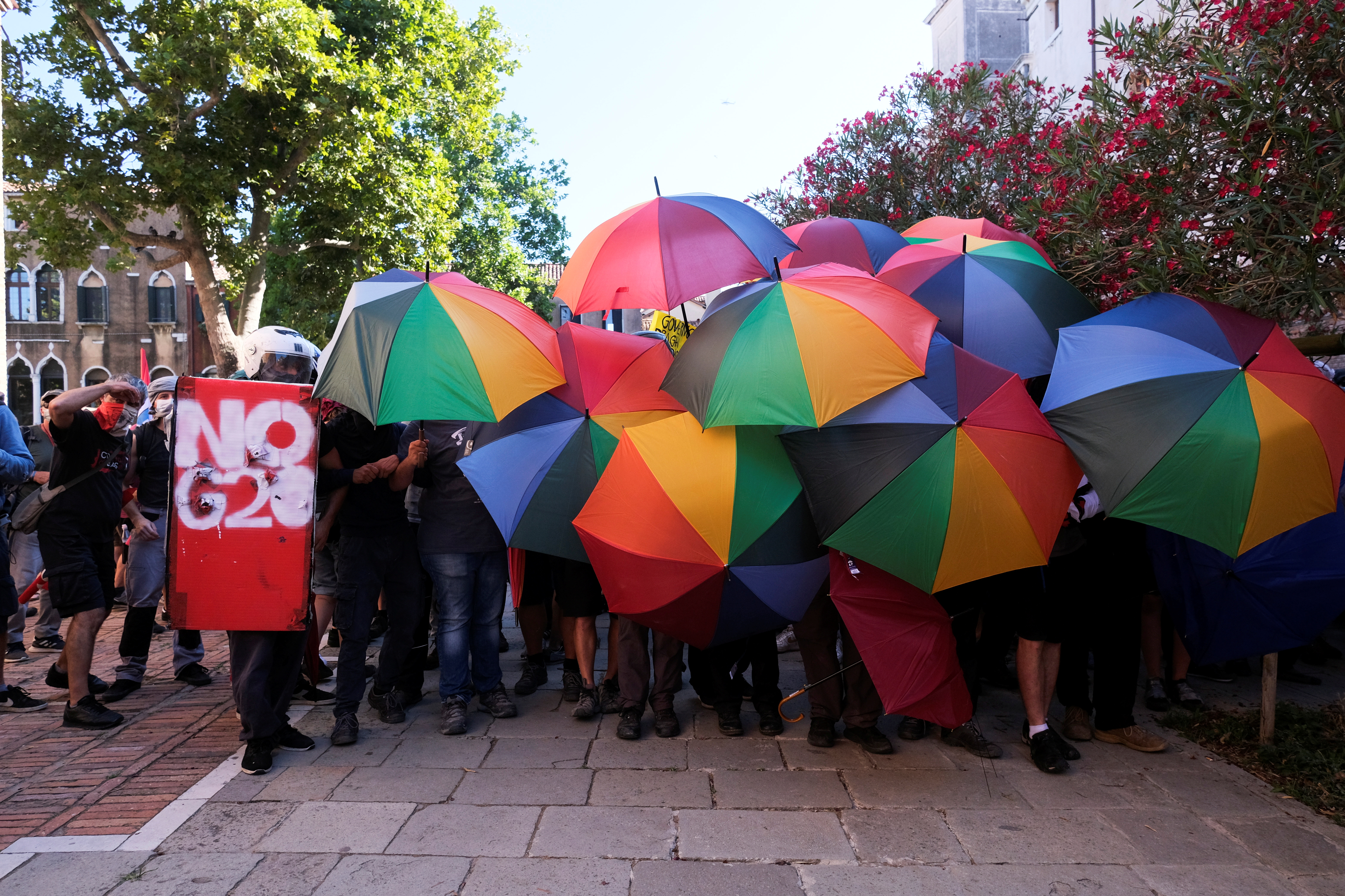 Protesters hold rainbow umbrellas as they demonstrate against finance ministers from G20 countries and their policies as they meet in Venice, in Venice, Italy, July 10, 2021. REUTERS/Manuel Silvestri