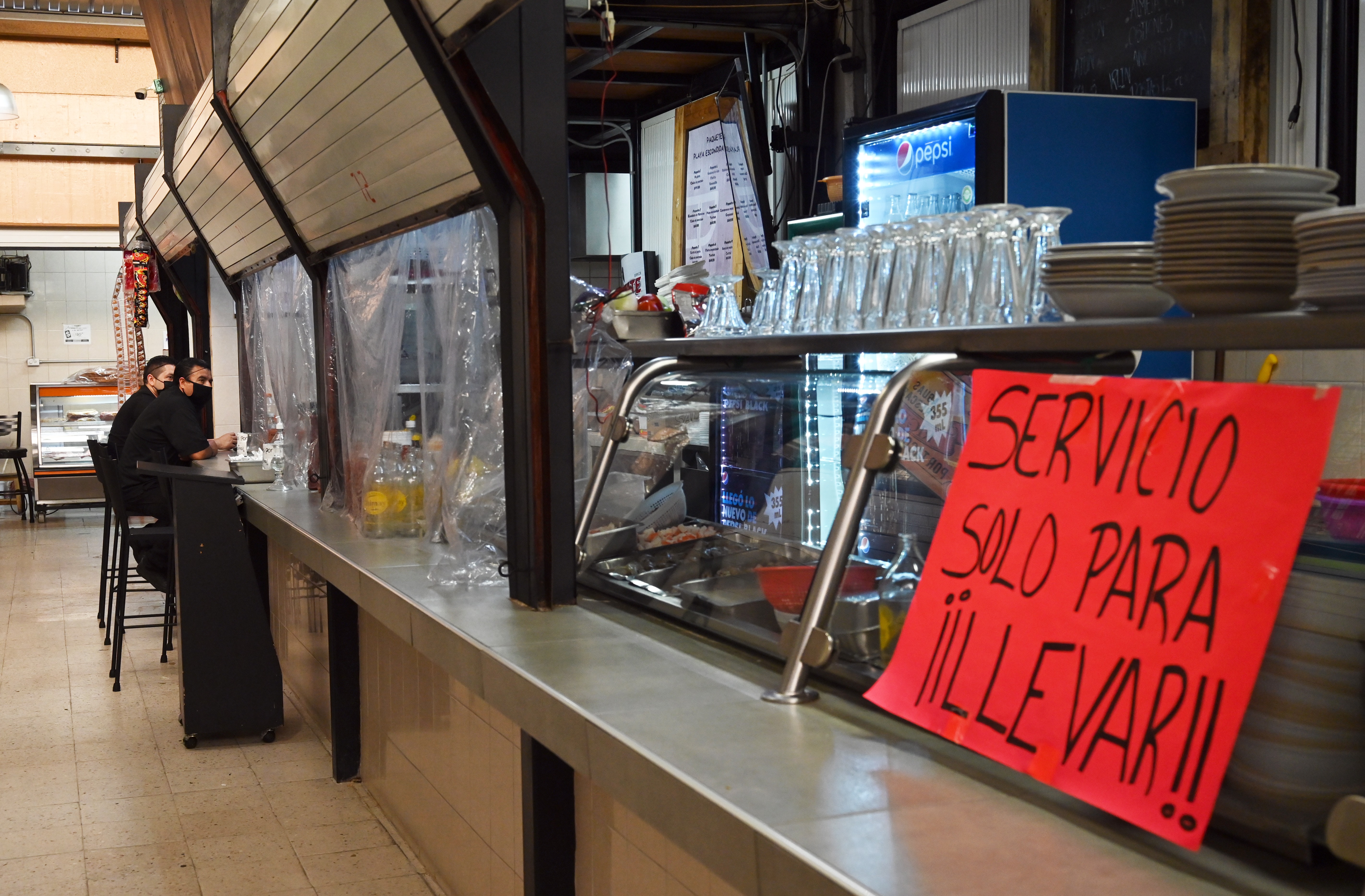 Los empleados de un restaurante esperan a los clientes mientras permanece cerrado al público en un mercado popular en la Ciudad de México el 29 de junio de 2020. (Foto: RODRIGO ARANGUA / AFP)