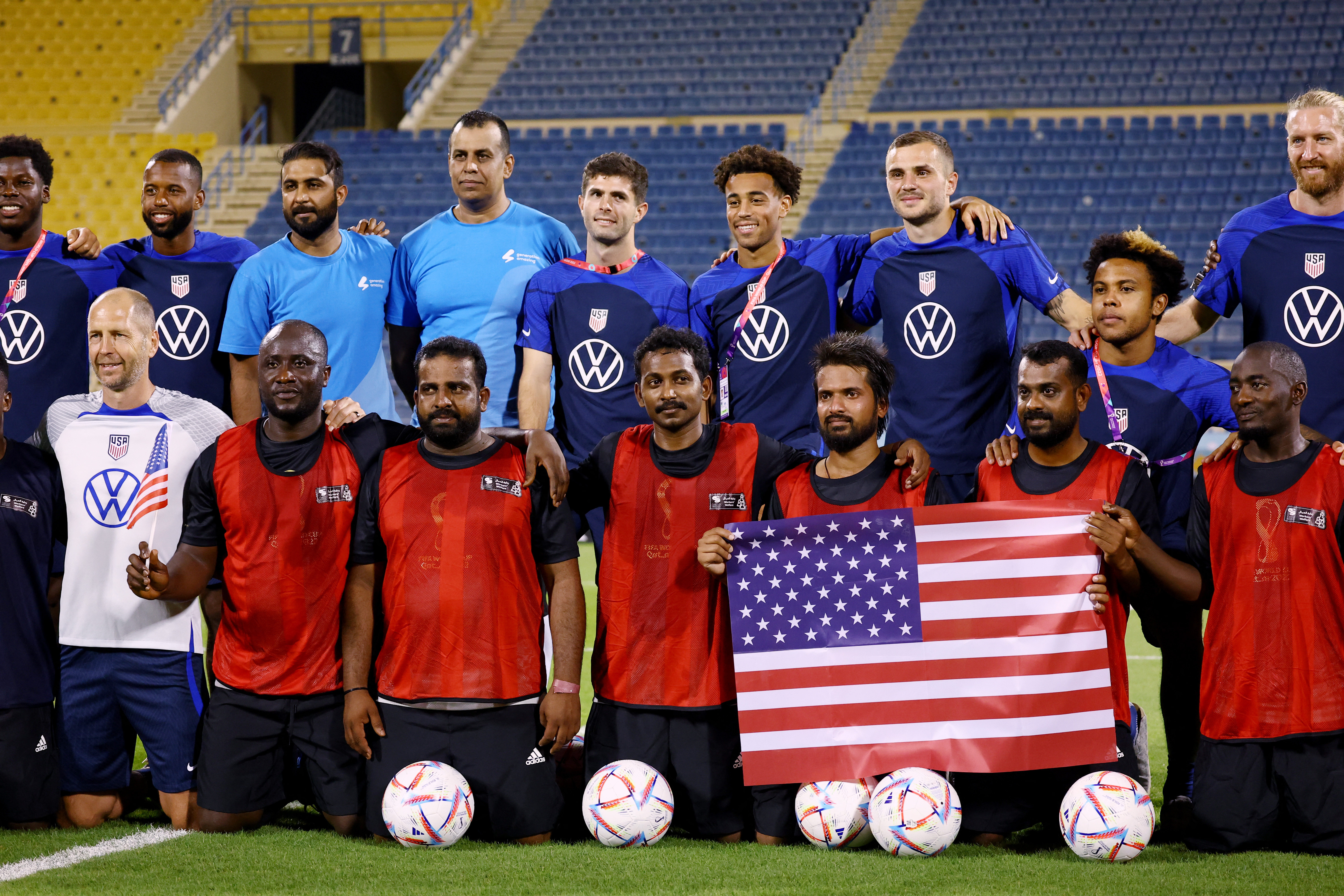 Soccer Football - FIFA World Cup Qatar 2022 - United States hold a welcome event with construction workers - Thani bin Jassim Stadium, Doha, Qatar - November 15, 2022 Christian Pulisic of the US and teammates pose with players from a construction workers team REUTERS/Kai Pfaffenbach