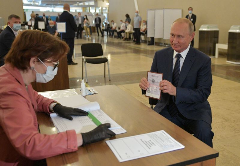 Vladimir Putin muestra su pasaporte durante su voto en el referéndum por la reforma constitucional el 1 de julio de 2020. (Sputnik/Alexei Druzhinin/Kremlin via REUTERS)
