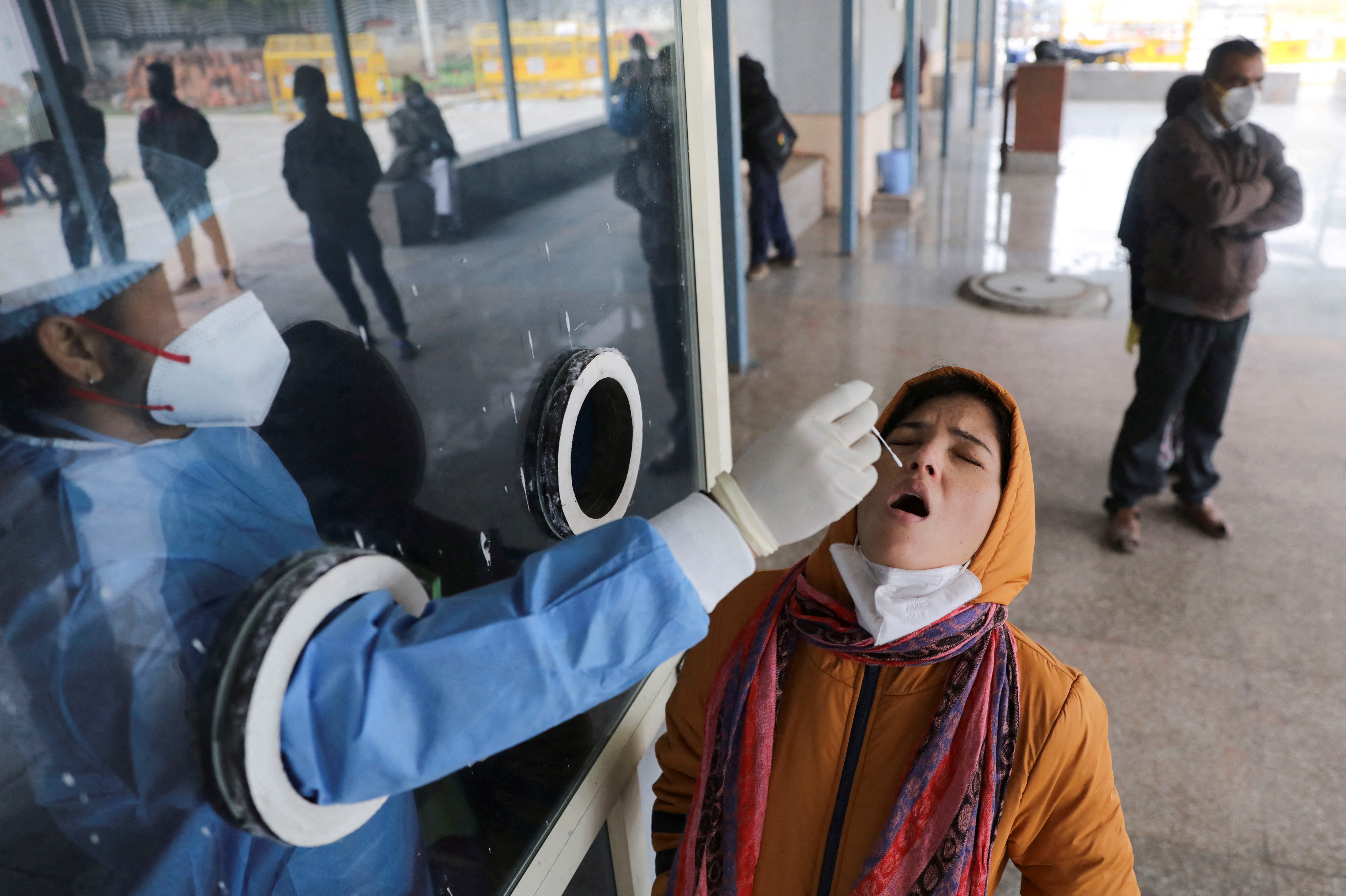 Un trabajador de la salud recolecta una muestra de hisopo en un centro de pruebas dentro de un hospital en Nueva Delhi (Reuters)