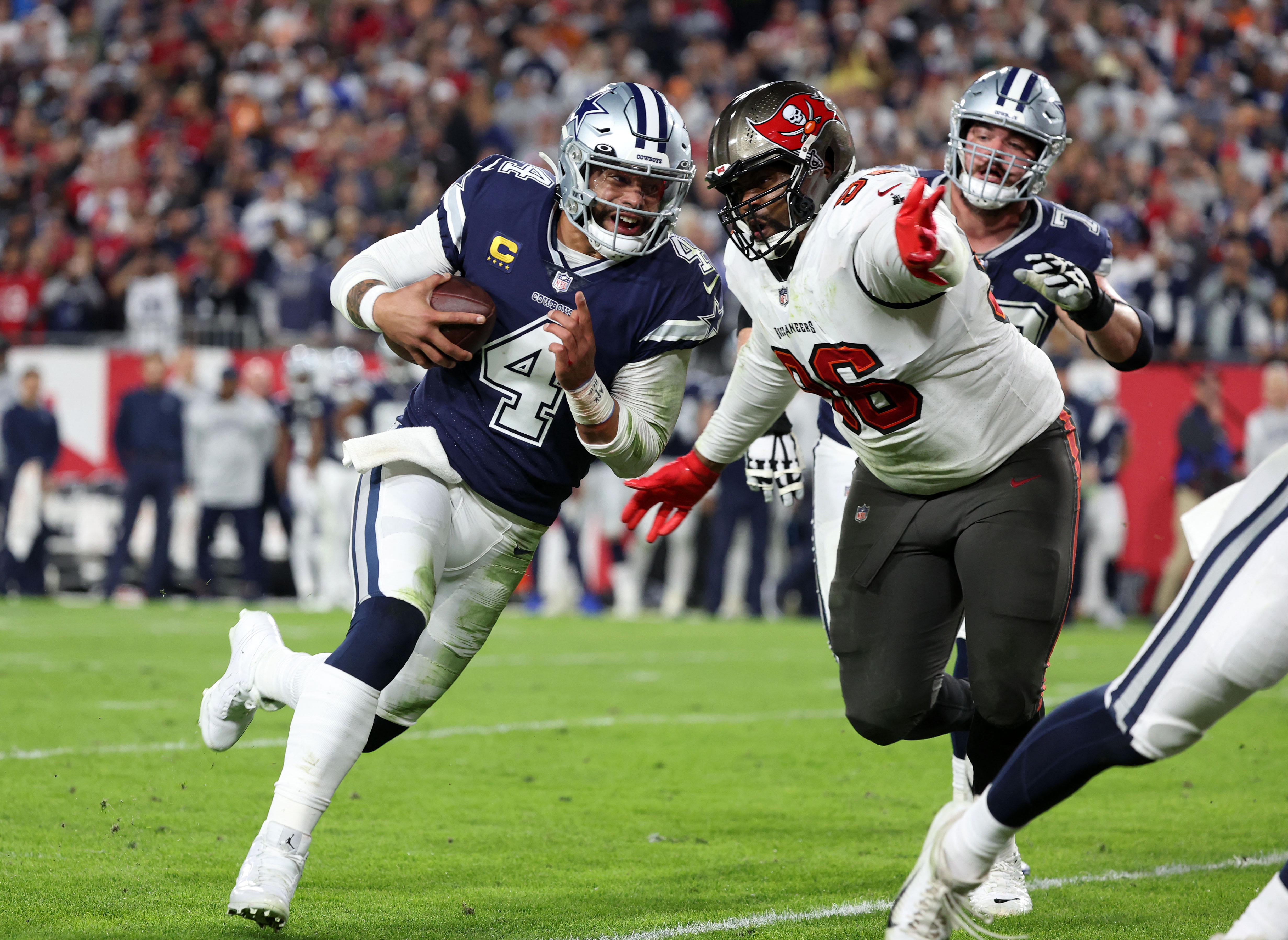 Jan 16, 2023; Tampa, Florida, USA; Dallas Cowboys quarterback Dak Prescott (4) rushes the ball for a touchdown against the Tampa Bay Buccaneers in the first half during the wild card game at Raymond James Stadium. Mandatory Credit: Kim Klement-USA TODAY Sports