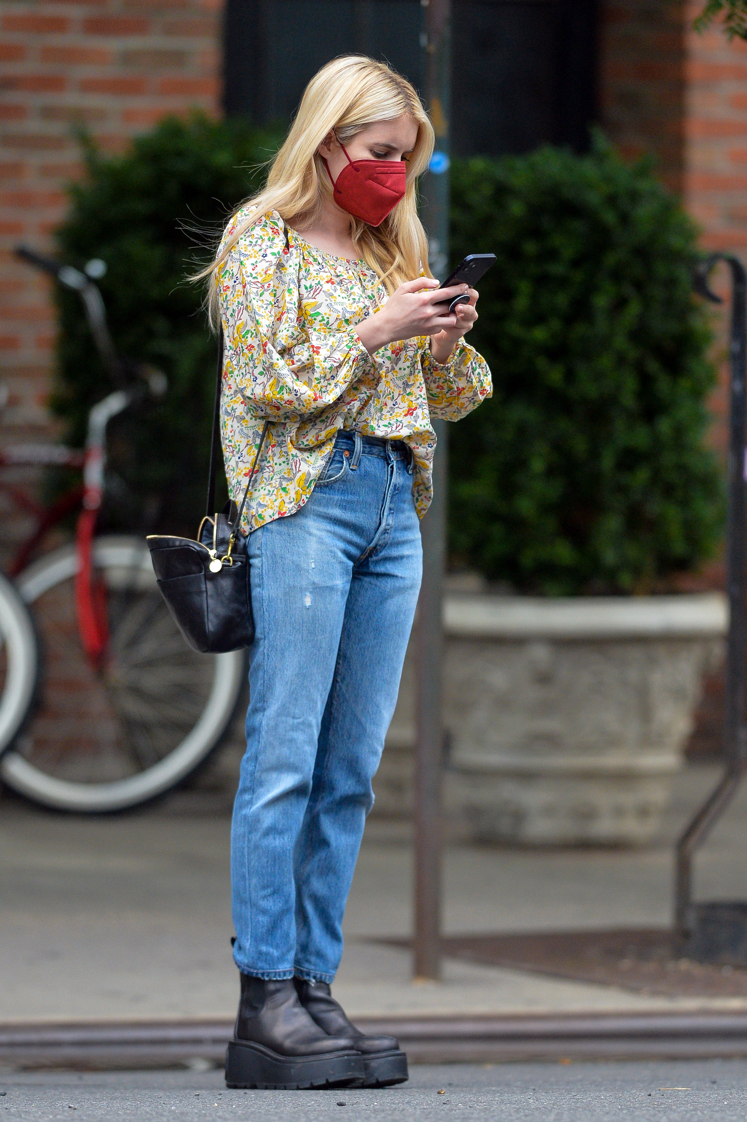 Emma Roberts dio un paseo por las calles de Nueva York. Lució una camisa estampada de flores, un jean, cartera negra que combinó con sus borcegos y un tapabocas color rojo (Fotoso: The Grosby Group)