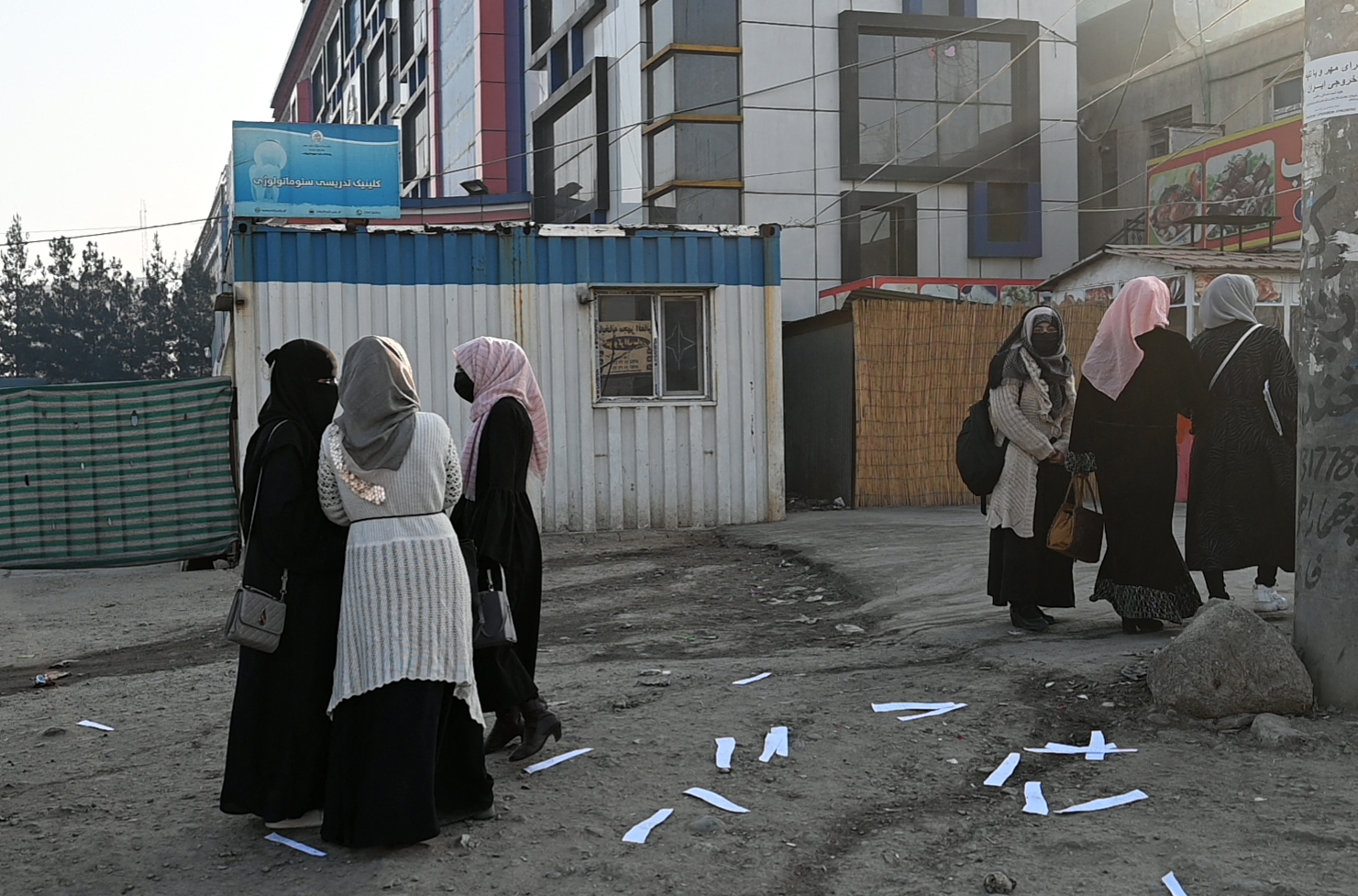 Afghan university students walk home in front of a private university in Kabul on December 21, 2022. (Wakil KOHSAR / AFP)
