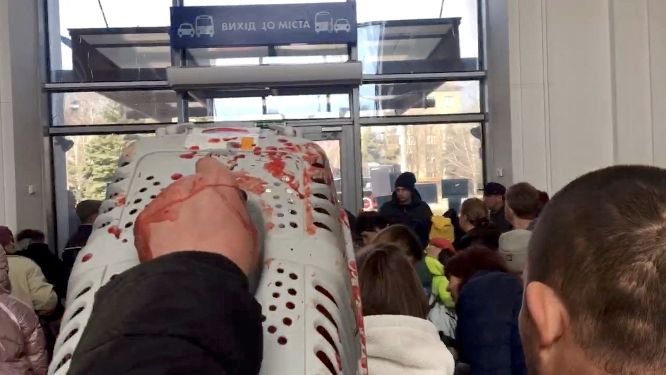 Un hombre lleva un transportador de animales manchado de sangre después del ataque en la estación de tren de Kramatorsk