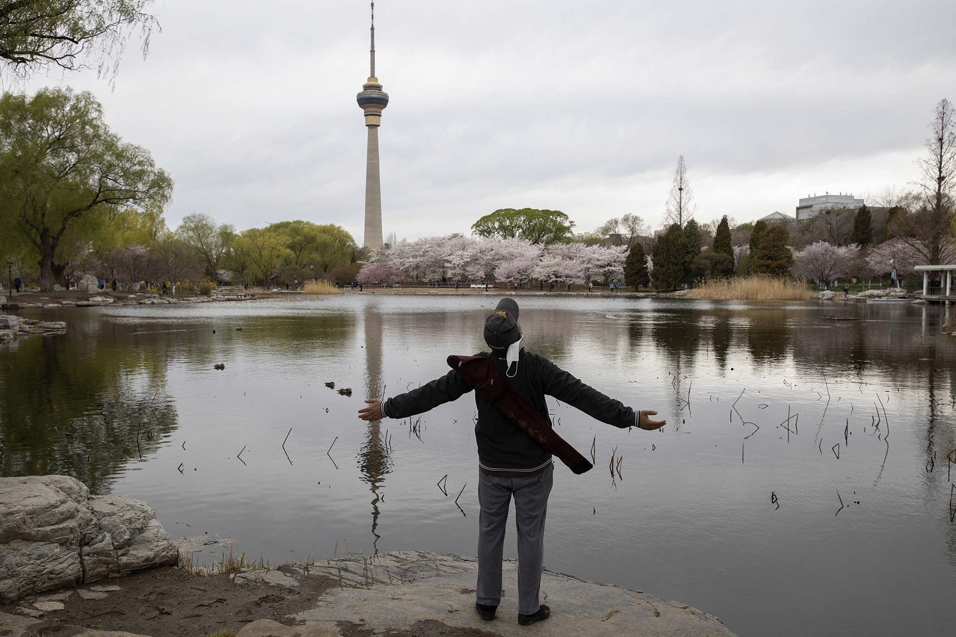 Un hombre se quita su máscara facial y respira mirando al cielo en el Parque Yuyuantan en Beijing (AP Photo/Ng Han Guan)