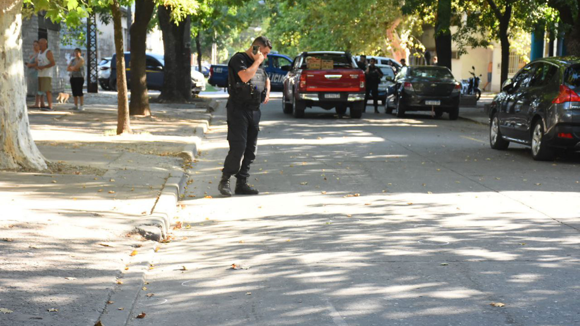 Un efectivo de la Policía observa las vainas que quedaron desparramadas en la calle
