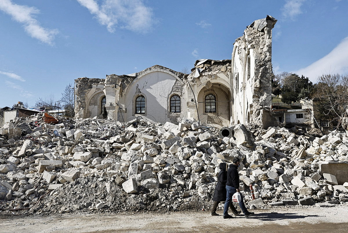 Un grupo de personas camina cerca de una mezquita dañada tras un terremoto mortal en Adiyaman, Turquía, el 15 de febrero de 2023. REUTERS/Thaier Al-Sudani
