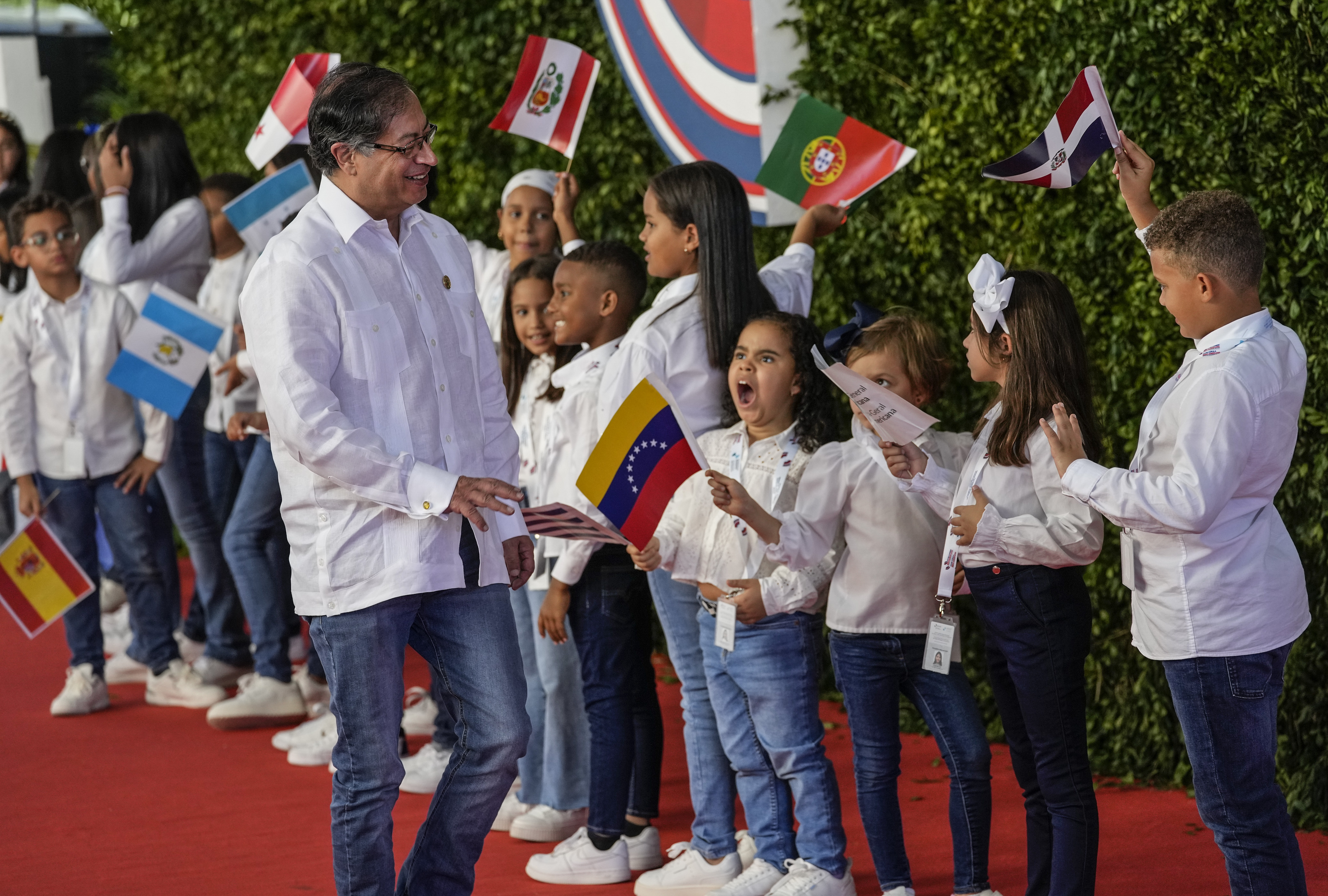 El presidente de Colombia, Gustavo Petro, saluda a los niños a su llegada a la sesión de la 28ª Cumbre Iberoamericana, en Santo Domingo, República Dominicana, el sábado 25 de marzo de 2022. (Foto AP/Ariana Cubillos)