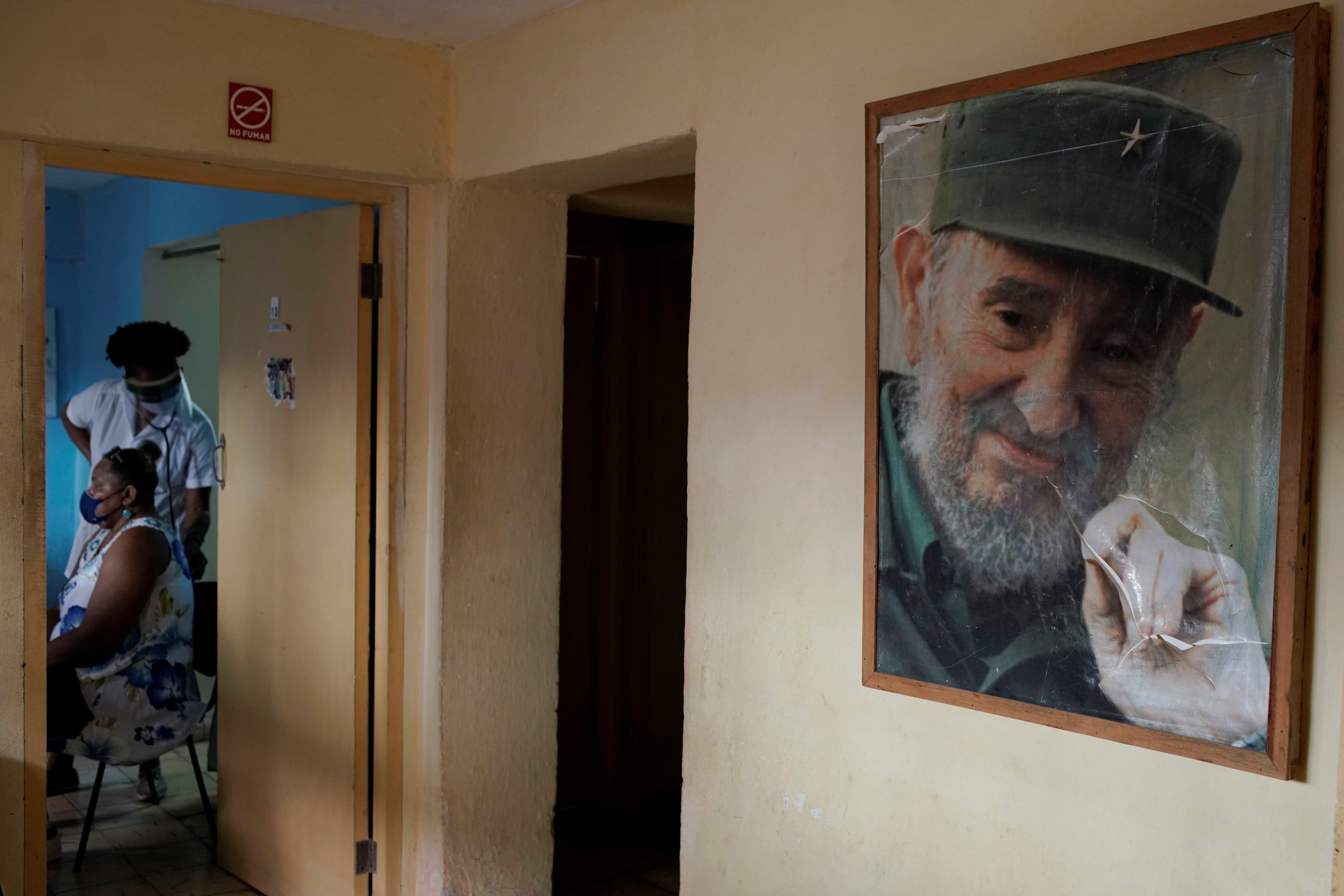 Una mujer cubana es atendida en un centro médico que tiene una foto del líder Fidel Castro, ya fallecido -REUTERS/Alexandre Meneghini