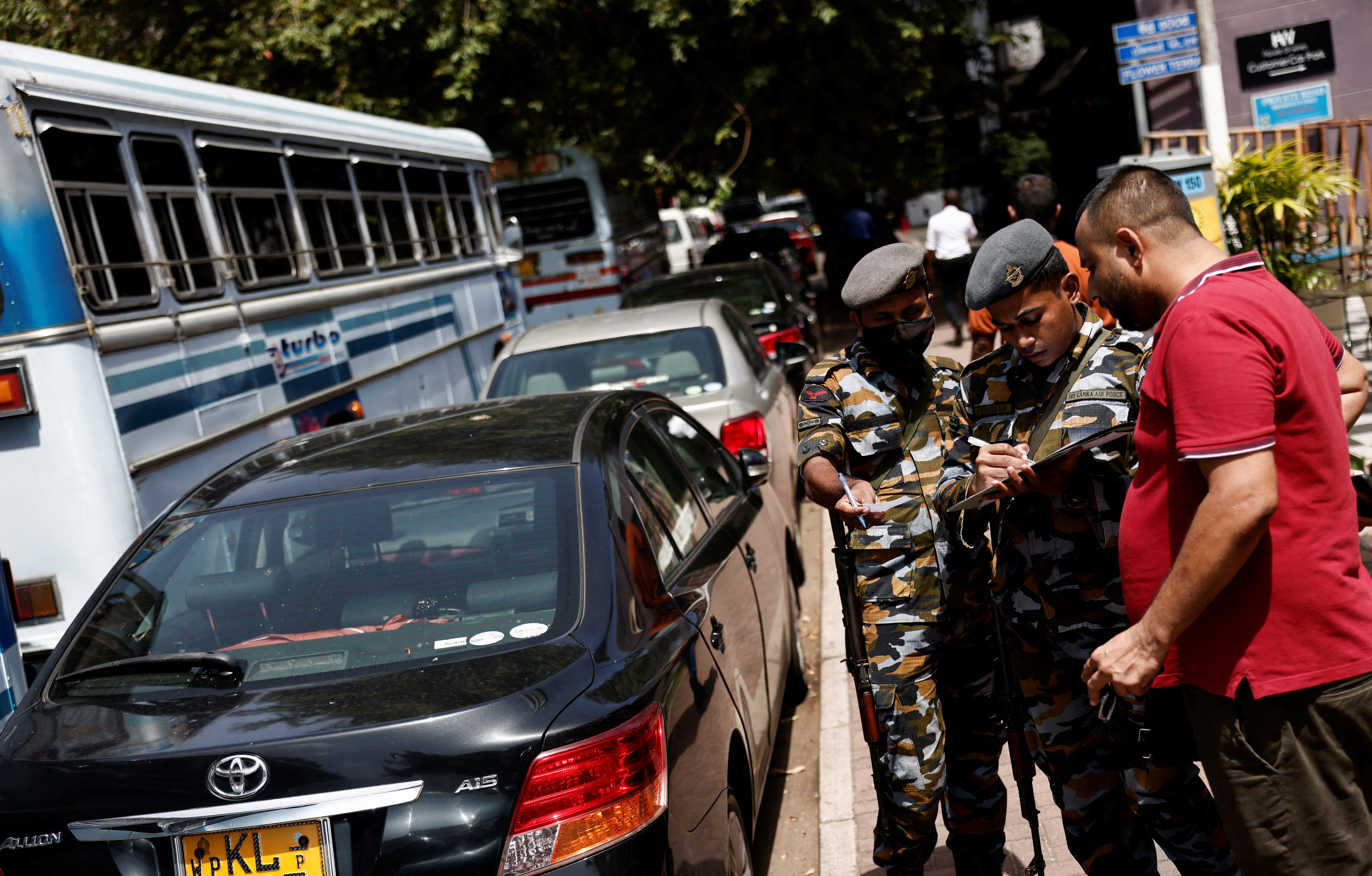 Los miembros de la Fuerza Aérea de Sri Lanka distribuyen fichas a las personas que hacen cola para obtener combustible debido a la escasez de combustible, en medio de la crisis económica del país, en Colombo, Sri Lanka 27 de junio, 2022. REUTERS/Dinuka Liyanawatte