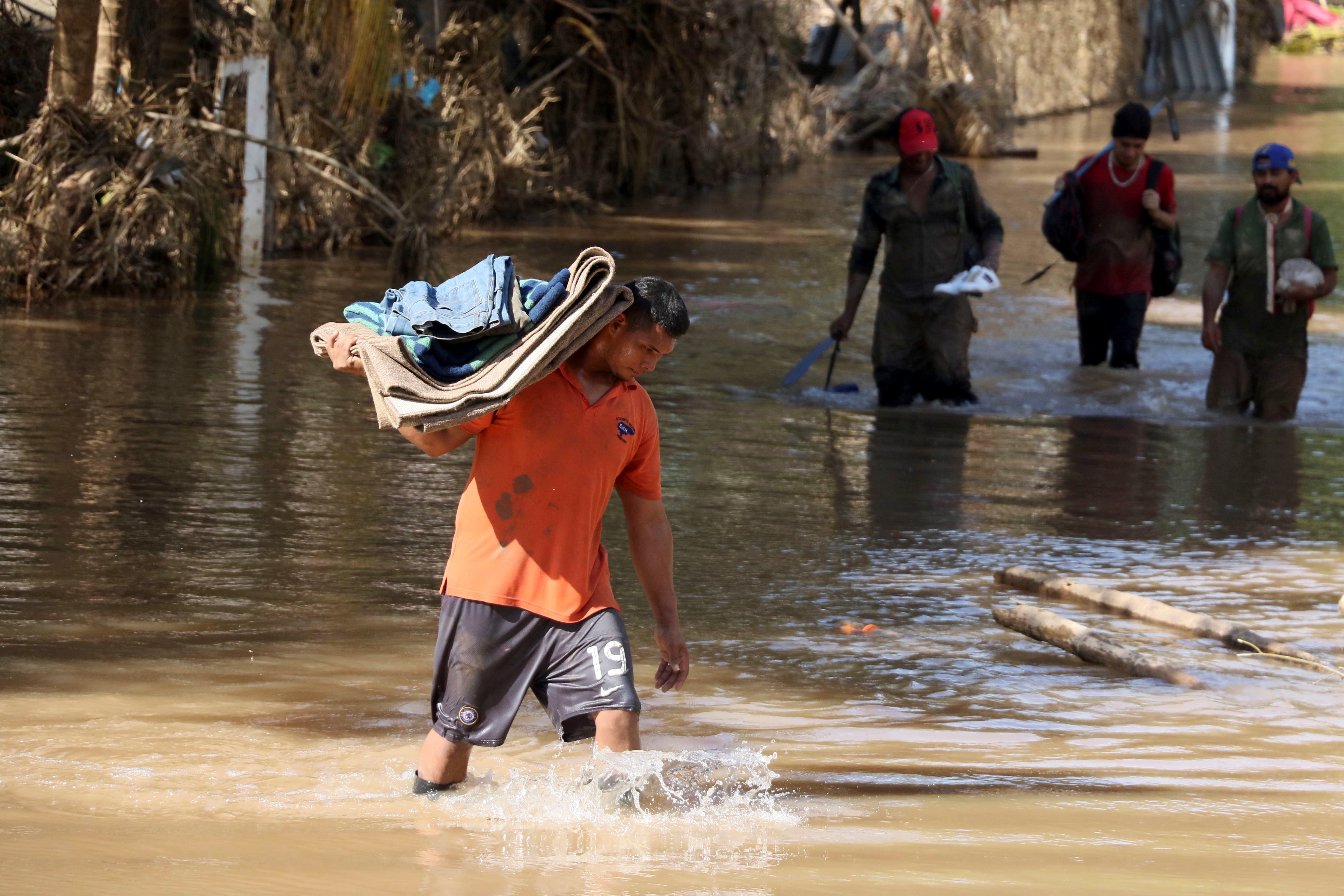 Un hombre damnificado por las tormentas tropicales Eta y Iota rescata algunas pertenencias en la comunidad La Guadalupe el 30 de noviembre de 2020. EFE/Germán Reyes
