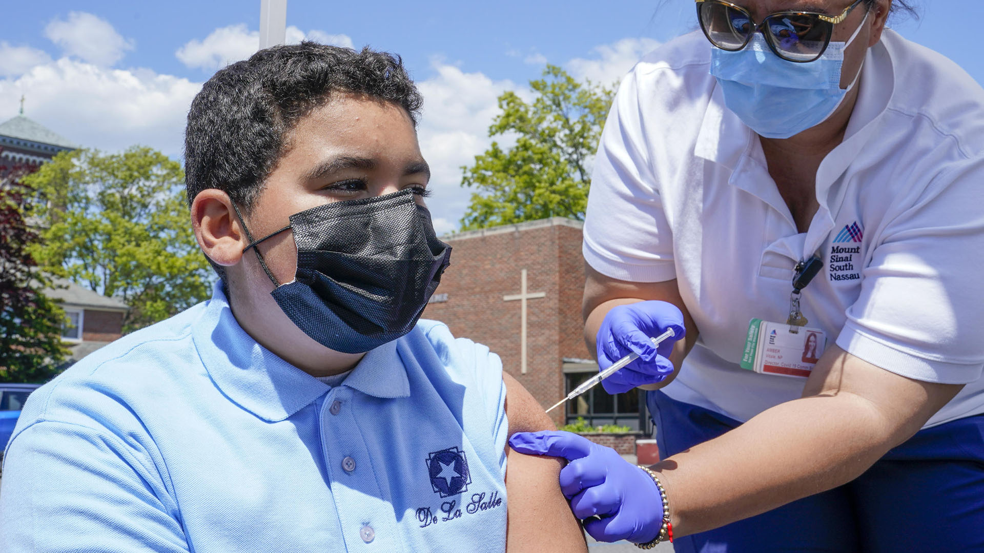 La enfermera Amber Vitale vacuna a Stanley Pena, de 13 años, con la primera dosis de la vacuna Pfizer COVID-19 en el Vaxmóvil de Mount Sinai South Nassau estacionado en la Escuela De La Salle, el viernes 14 de mayo de 2021, en Freeport, N.Y. (AP /Mary Altaffer)