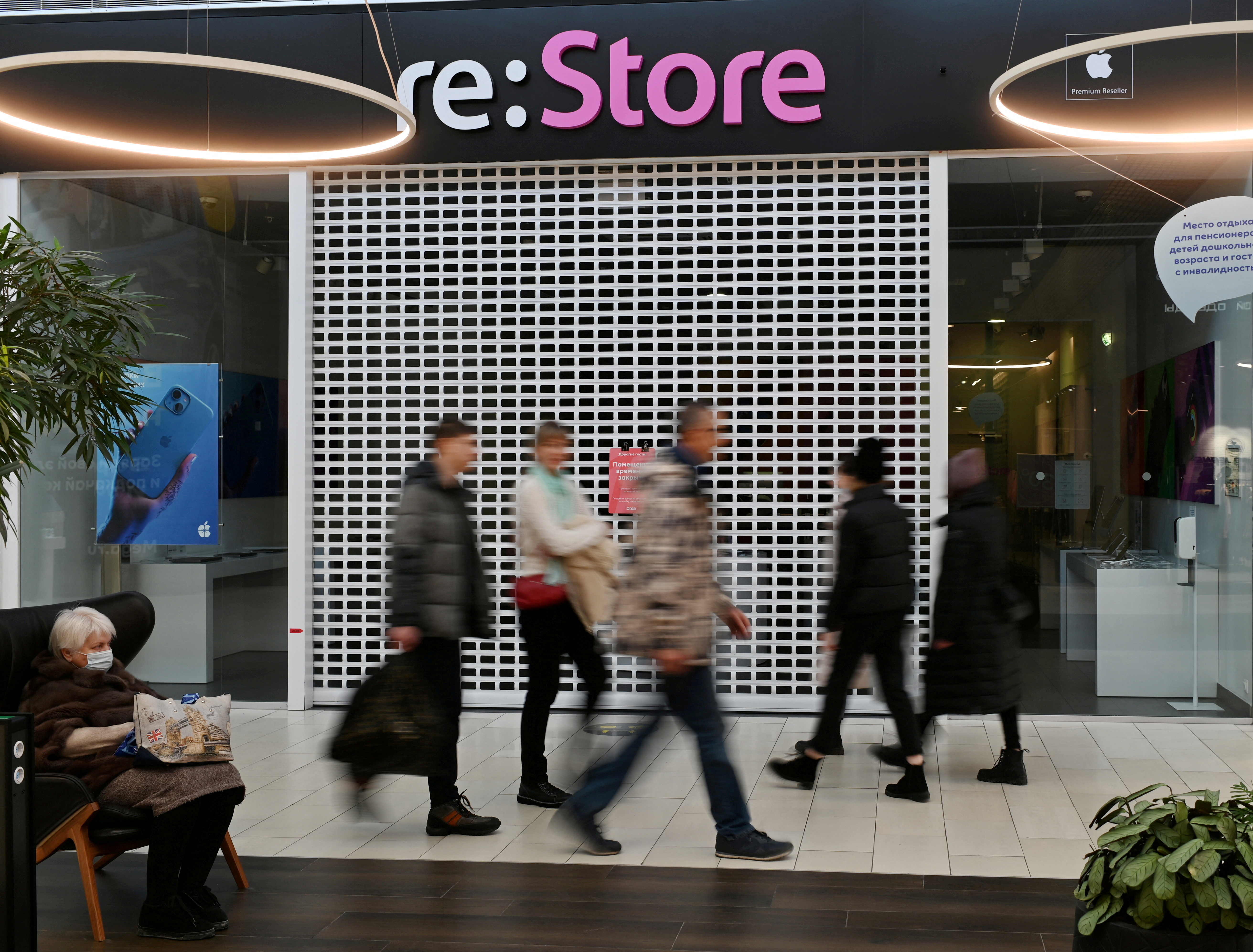 FOTO FILE: Orang-orang berjalan melewati toko Apple "memulihkan" ditutup di sebuah pusat perbelanjaan di Omsk, Rusia, pada 2 Maret 2022. REUTERS/File foto