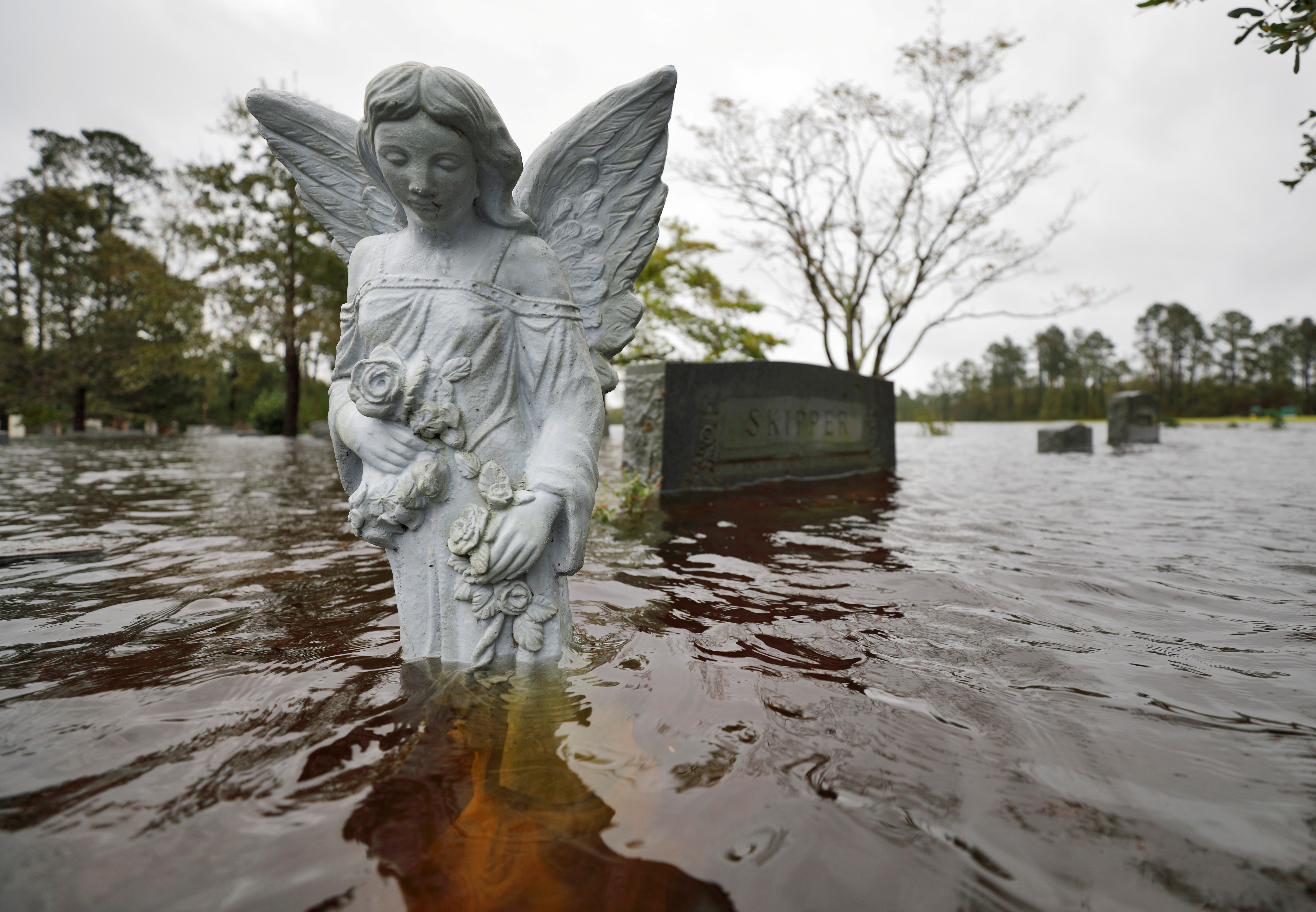 FOTO DE ARCHIVO: Una estatua de un ángel está parcialmente sumergida por las aguas de la inundación en el cementerio de una iglesia donde los residentes se refugiaron y luego fueron evacuados, después del huracán Florence en Leland, Carolina del Norte, el 16 de septiembre de 2018. (REUTERS / Jonathan Drake / Foto de archivo)