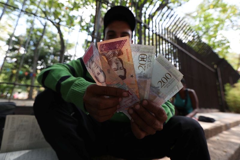 Un lugareño muestra billetes de la moneda venezolana, el bolívar, en una plaza de Caracas (REUTERS/Iván Alvarado/Archivo)