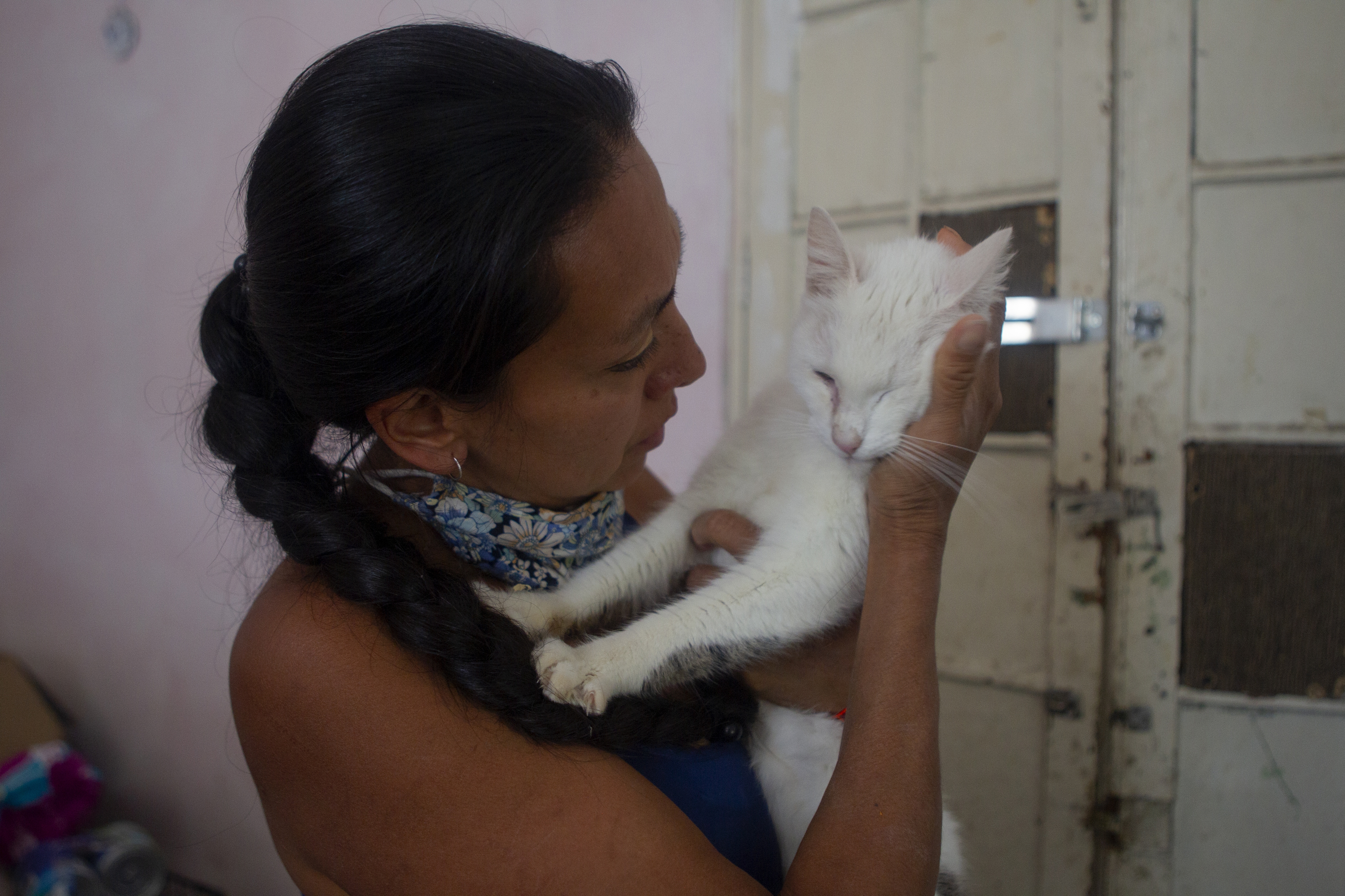 Dinah junto a un gato blanco en Adopta Amor, albergue dedicado al rescate de perros y gatos. Ciudad de México, mayo 28, 2021.Foto: Karina Hernández / Infobae