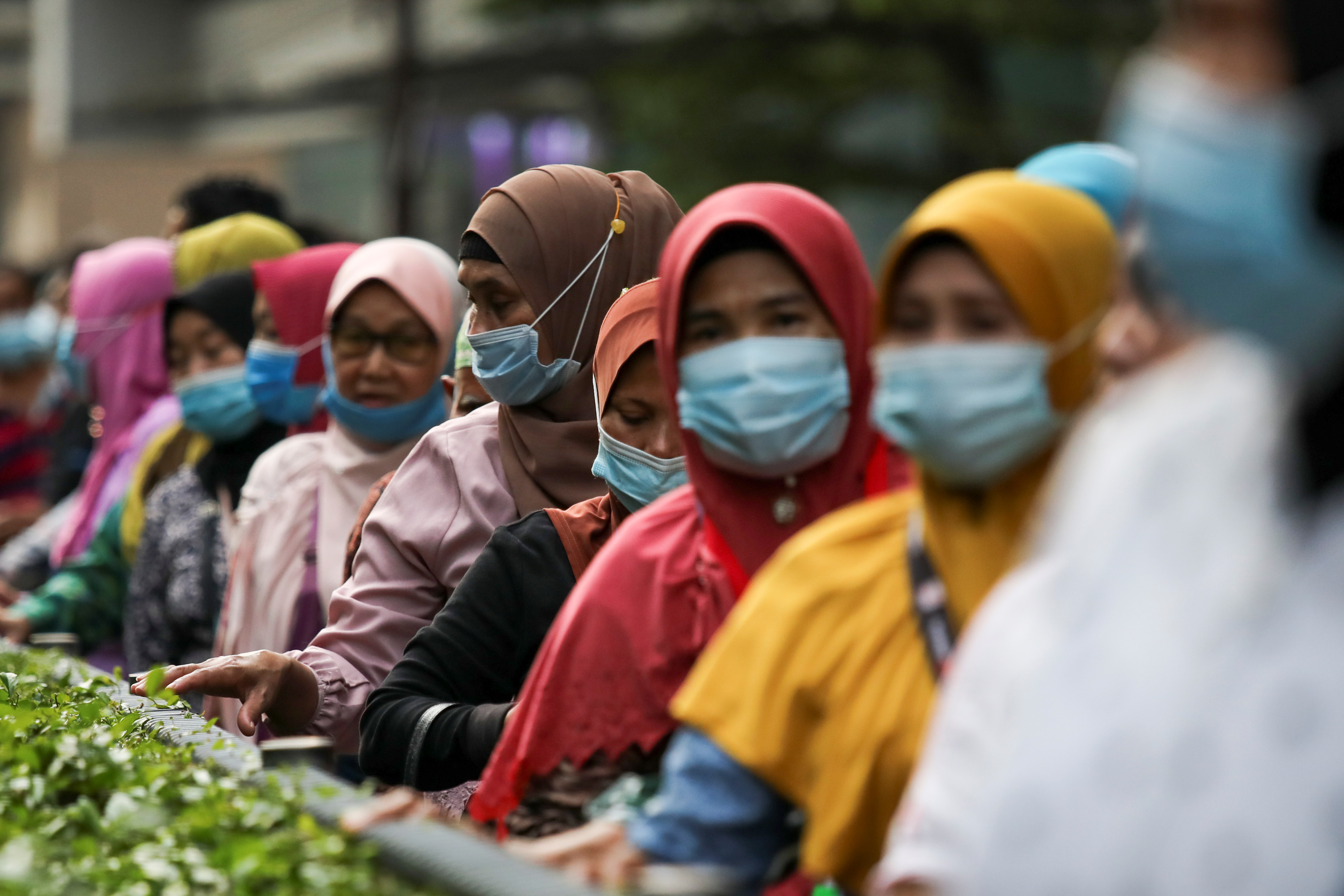 Pasajeros con barbijos en una parada de autobus en Kuala Lumpur (REUTERS/Lim Huey Teng)