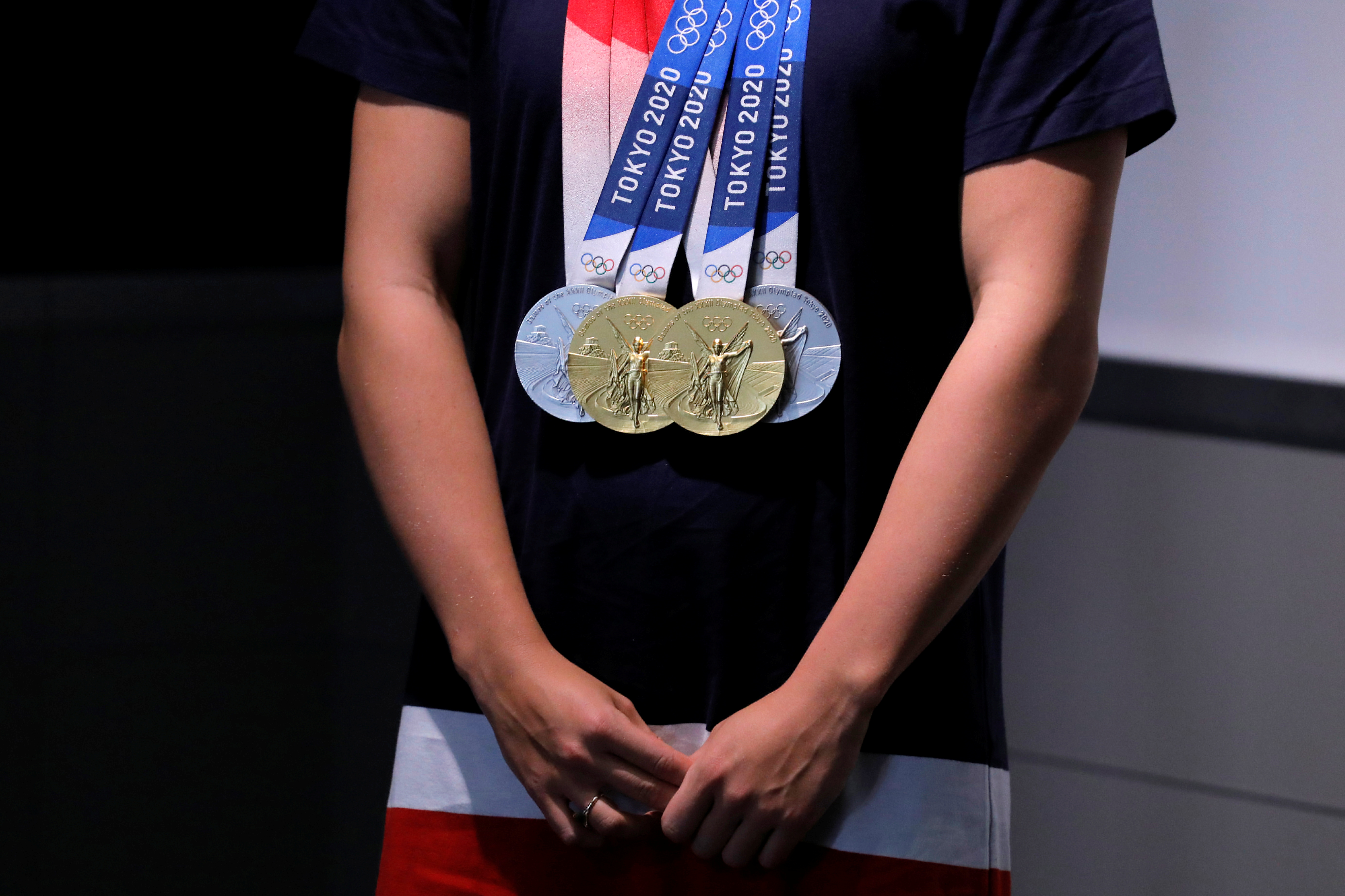 The Tokyo 2020 gold and silver medals of Olympic Team USA swimmer Katie Ledecky are seen hanging on her at the Empire State Building in Manhattan, New York City, U.S., August 12, 2021. REUTERS/Andrew Kelly