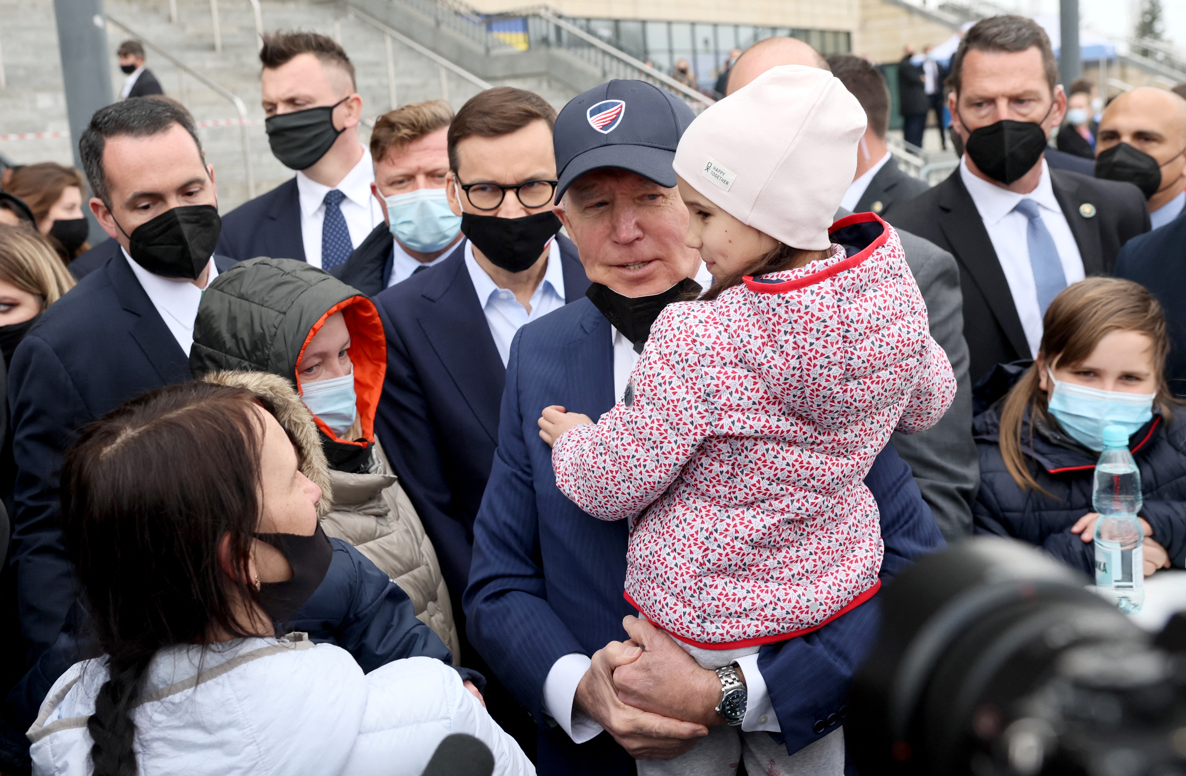 Joe Biden holds sostiene una niña ucraniana durante su visita al Estadio Nacional PGE, en Varsovia, Polonia (REUTERS/Evelyn Hockstein)