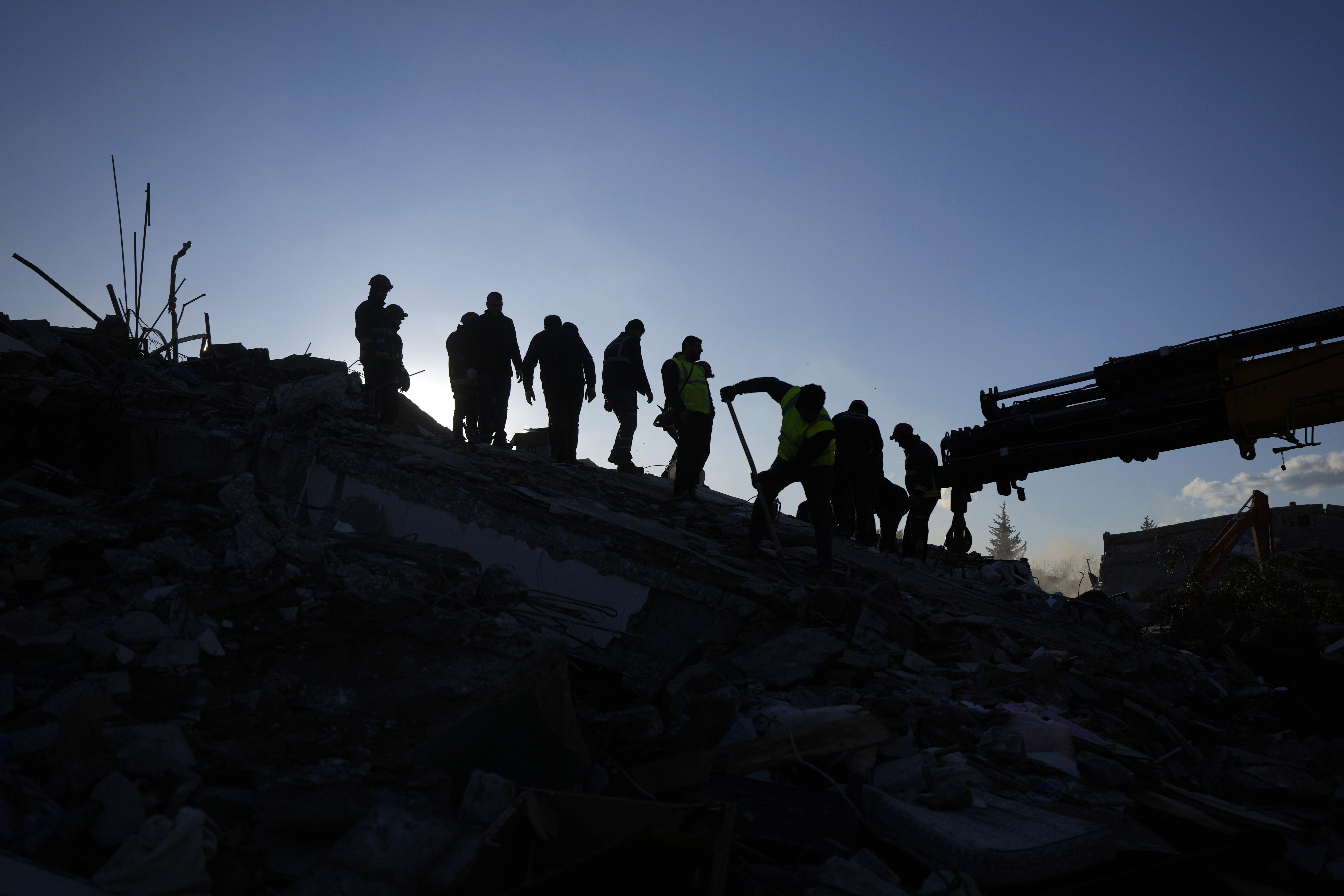 Rescue teams search for people among the rubble of destroyed buildings in Antakya, southern Turkey, on February 8, 2023. As hopes of finding survivors dwindled, exhausted rescue teams in Turkey and Syria searched for signs of life among the thousands of buildings demolished by a catastrophic earthquake.  (AP Photo/Khalil Hamra)