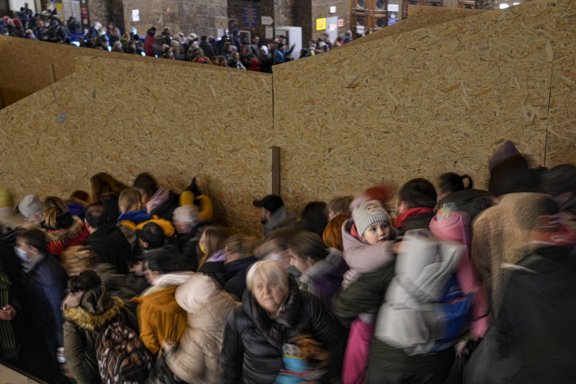 Gente trata de avanzar por las escaleras tras un cambio de última hora del andén de salida de un tren con destino a Leópolis en Kiev, Ucrania, el lunes 28 de febrero de 2022.