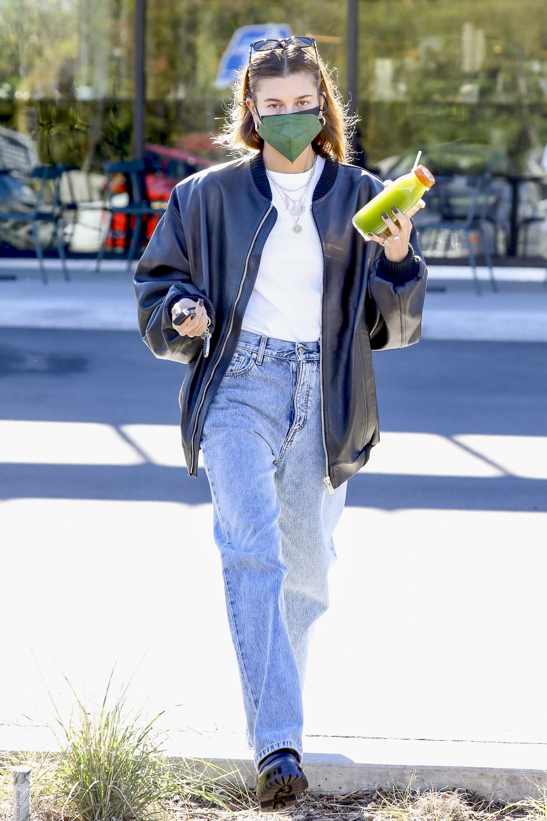 Hailey Bieber fue a comprar bebida para llevar en una reconocida tienda saludable de Los Ángeles. La esposa de Justin Bieber vistió un look casual: remera blanca básica, un jean, y una campera de cuero negra. Además, llevó tapabocas color verde y lentes de sol sobre su cabeza