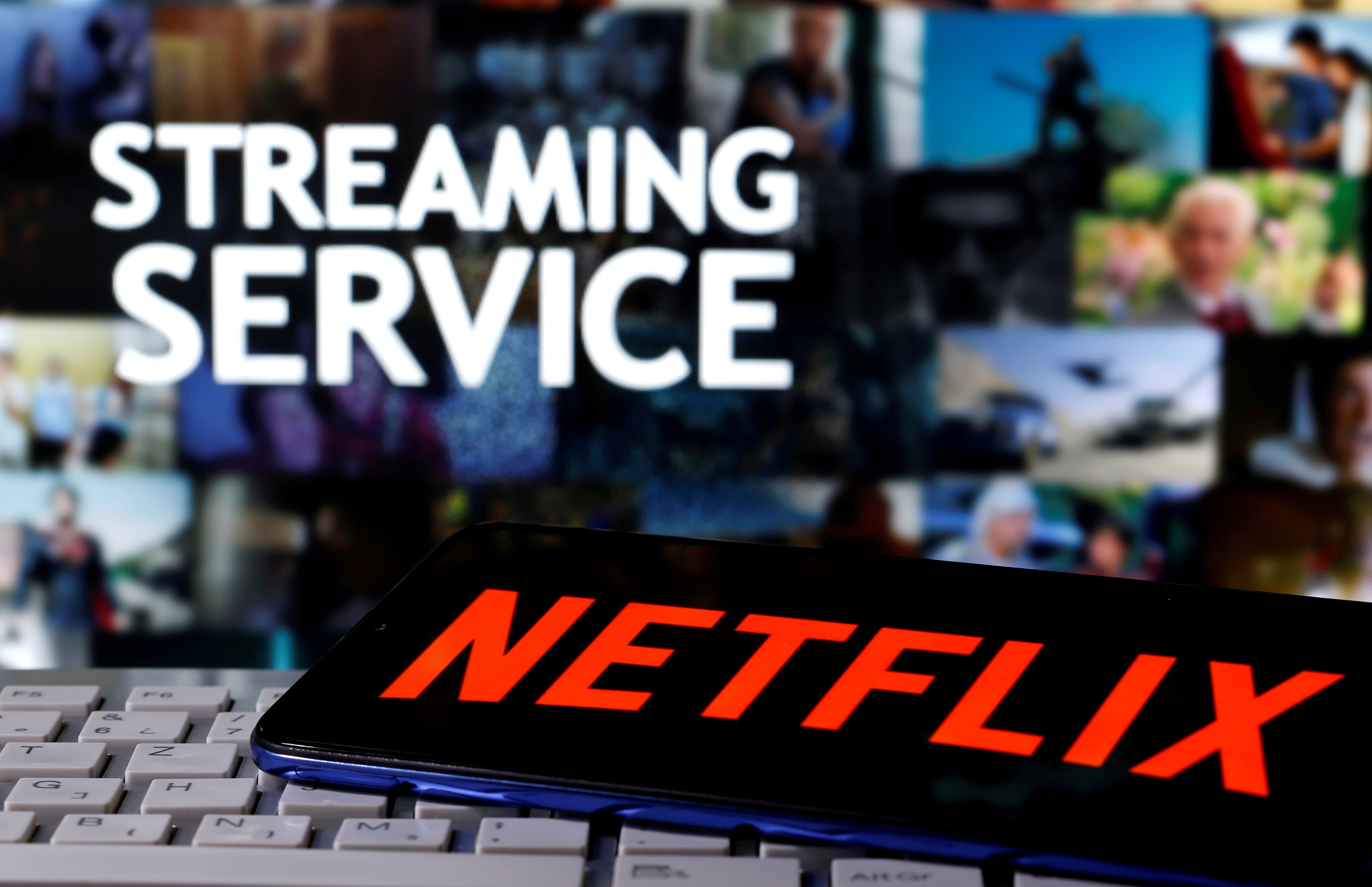 FILE PHOTO: A smartphone with the Netflix logo is seen on a keyboard in front of displayed "Streaming service" words in this illustration taken March 24, 2020. REUTERS/Dado Ruvic/File Photo