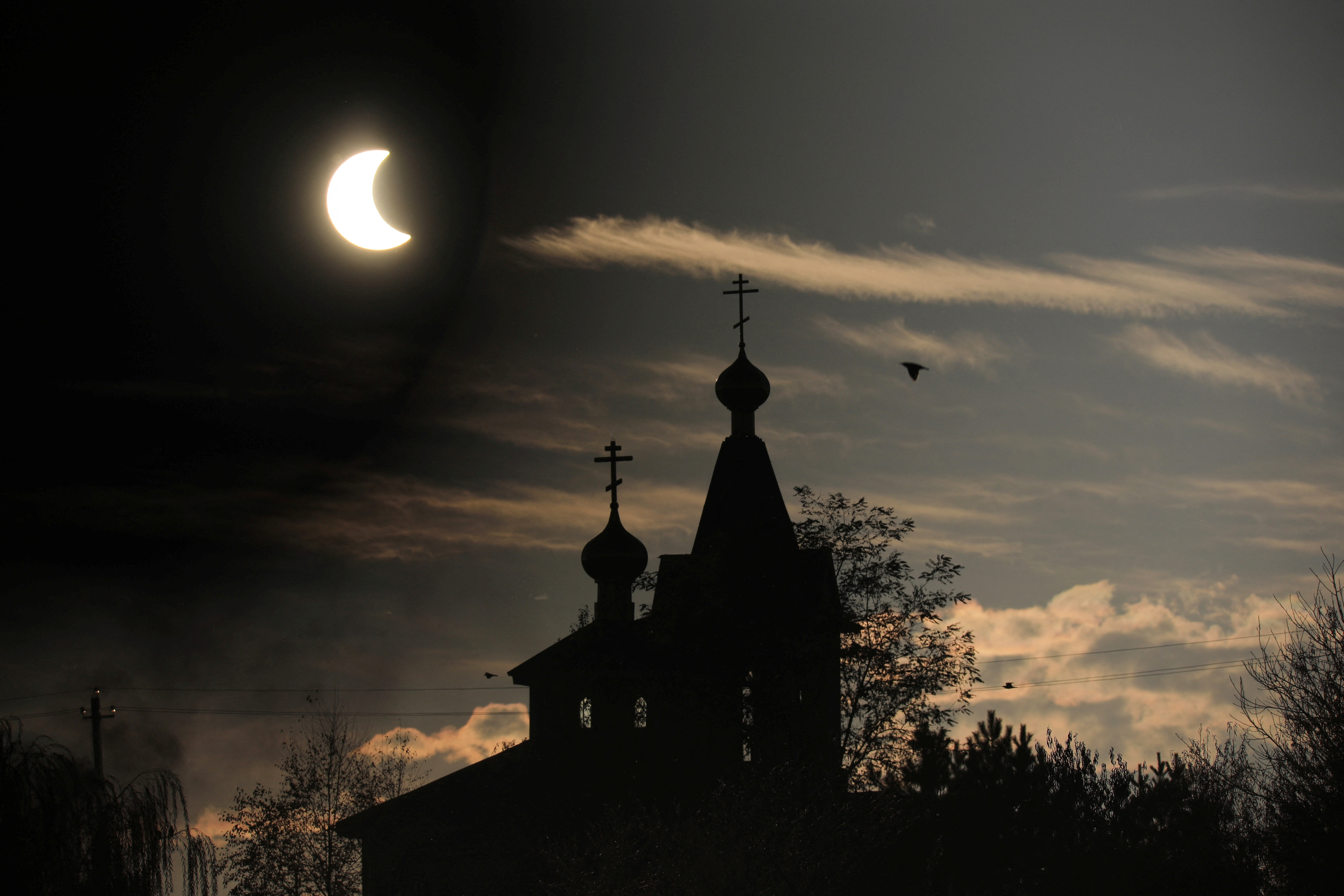 El eclipse solar sobre una iglesia en la ciudad de Almatý, en Kazajistán (REUTERS/Pavel Mikheyev)