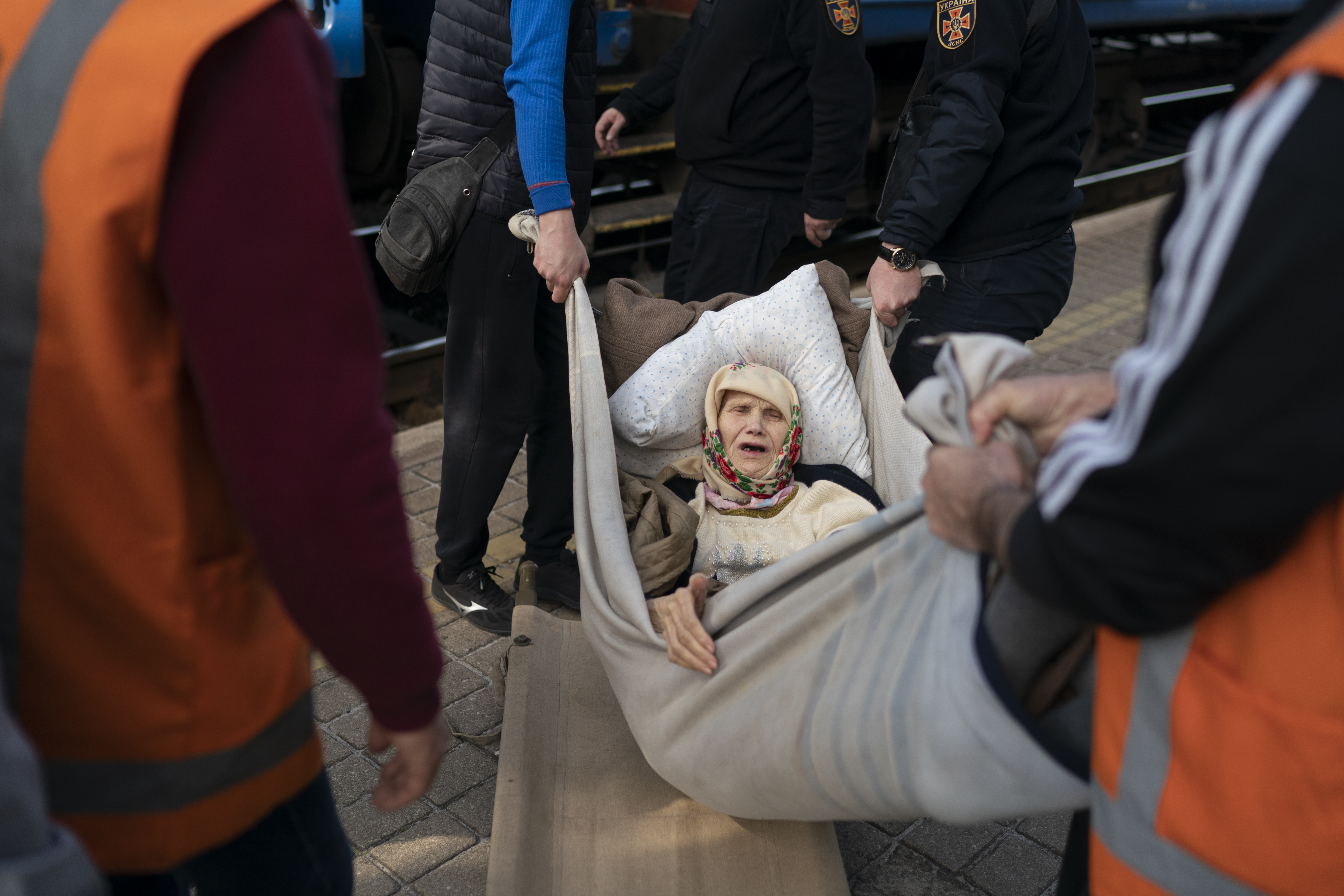 Una mujer, de 91 años, es transportada en una camilla improvisada mientras aborda un tren, huyendo de la guerra en Severodonetsk en una estación de tren en Pokrovsk, Ucrania (Foto AP/Leo Correa)