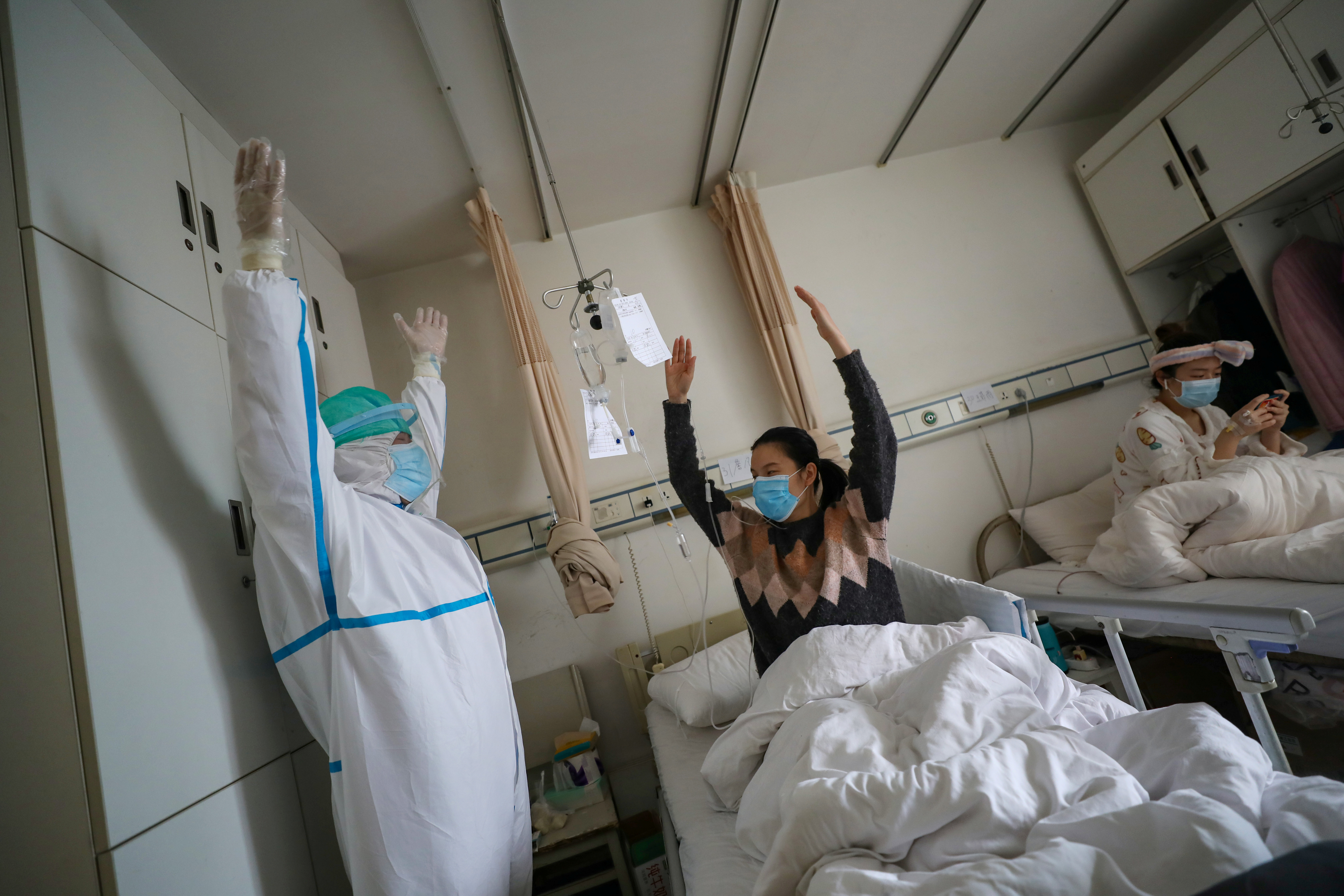 Un médico realiza ejercicios de kinesiología en un hospital de la Cruz Roja en Wuhan con un paciente de coronavirus en recuperación  (China Daily via REUTERS)