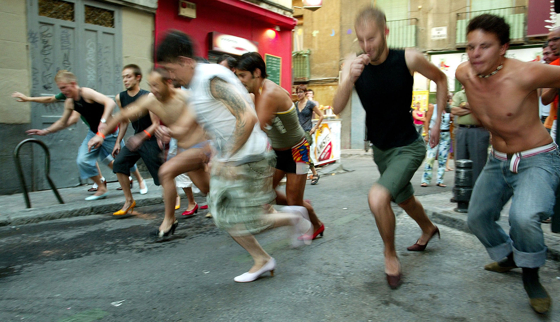 Varios hombres participan en una carrera de tacones en la fiesta del orgullo gay en el barrio de Chueca en Madrid el 1 de julio de 2005