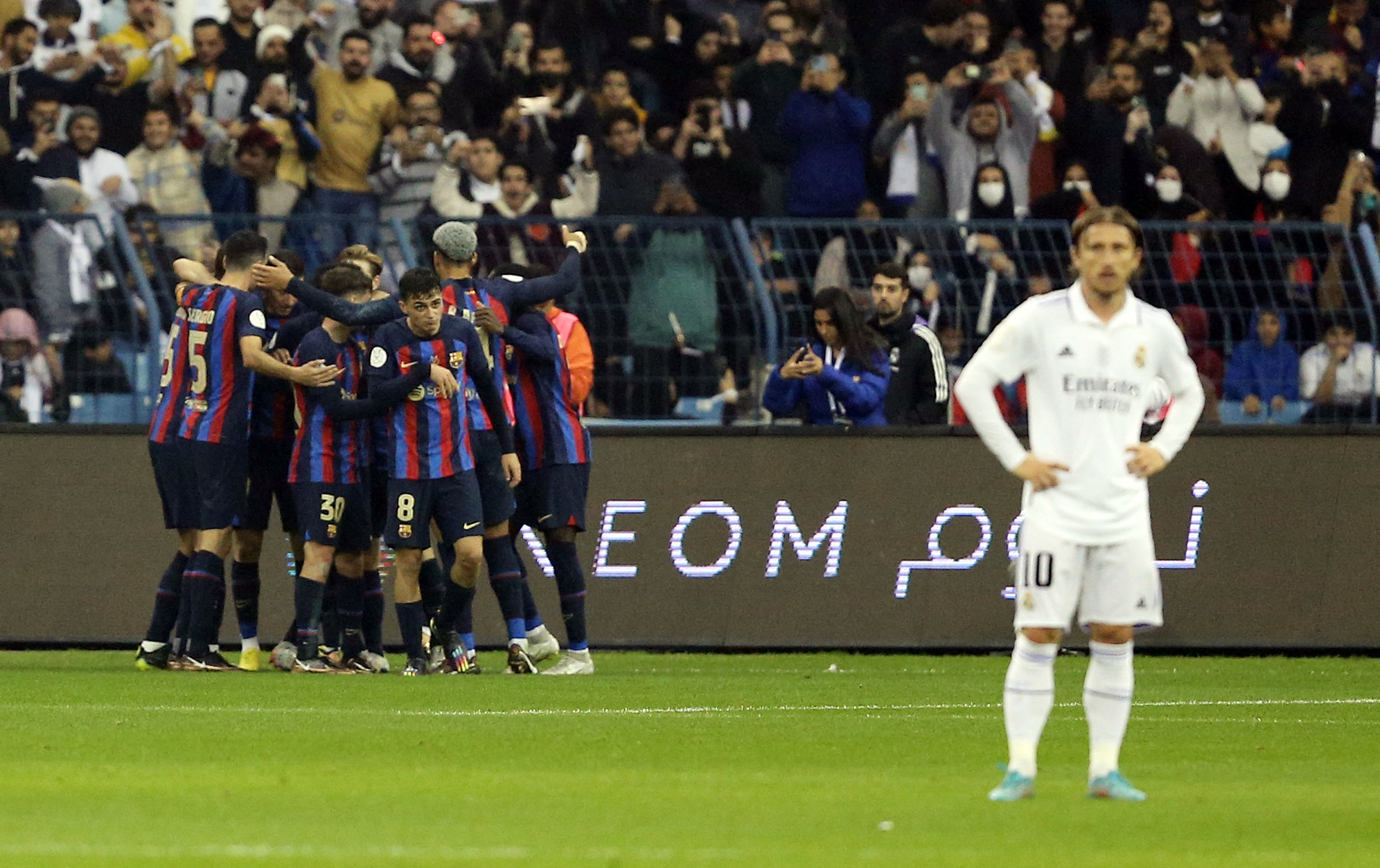 Los jugadores celebran el segundo gol del Barcelona ante la desilusión de Luka Modric. Foto: REUTERS/Ahmed Yosri