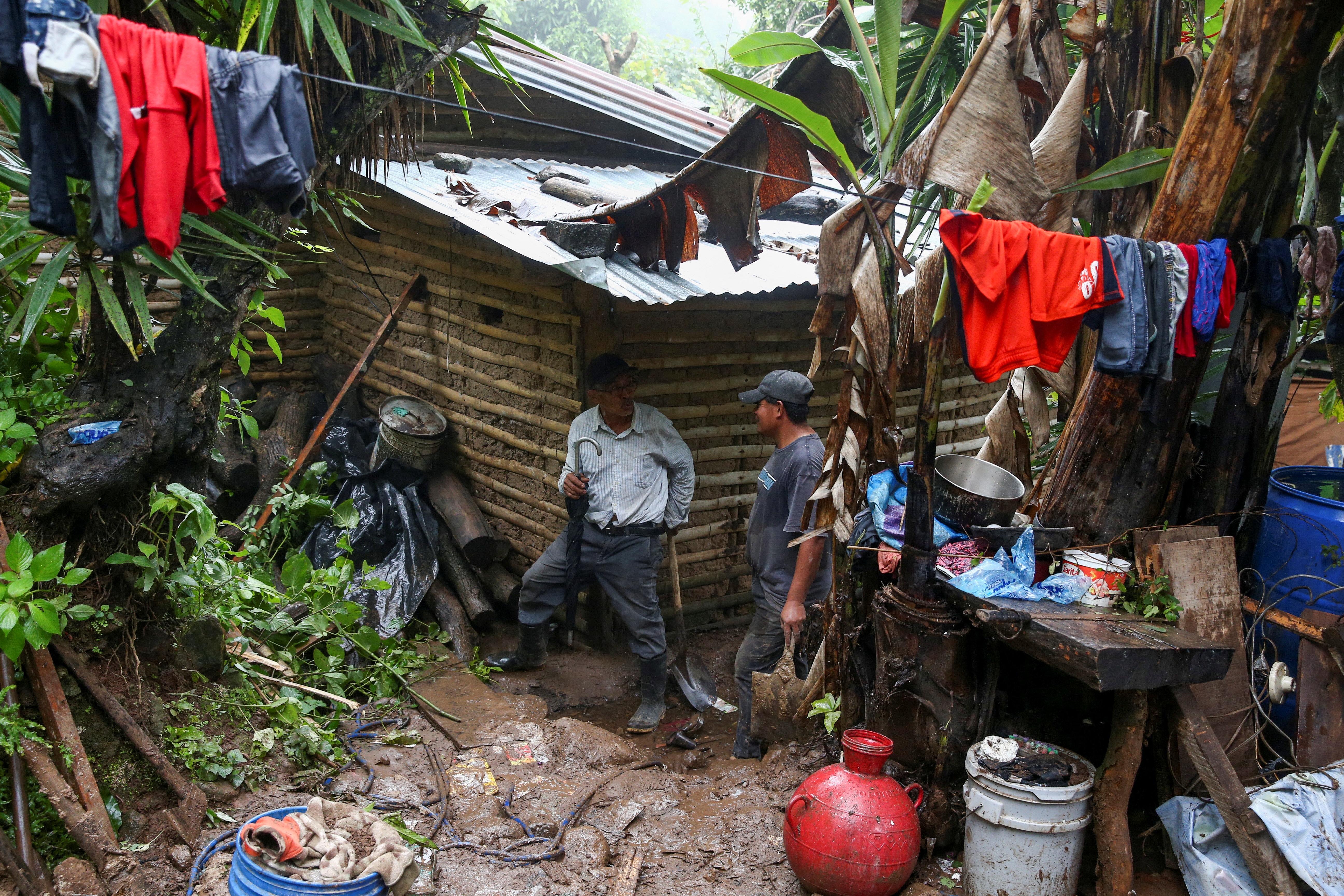 Familiares permanecen cerca del lugar donde murieron cinco personas tras un deslave provocado por las constantes lluvias, en Huizúcar (REUTERS/Jose Cabezas)