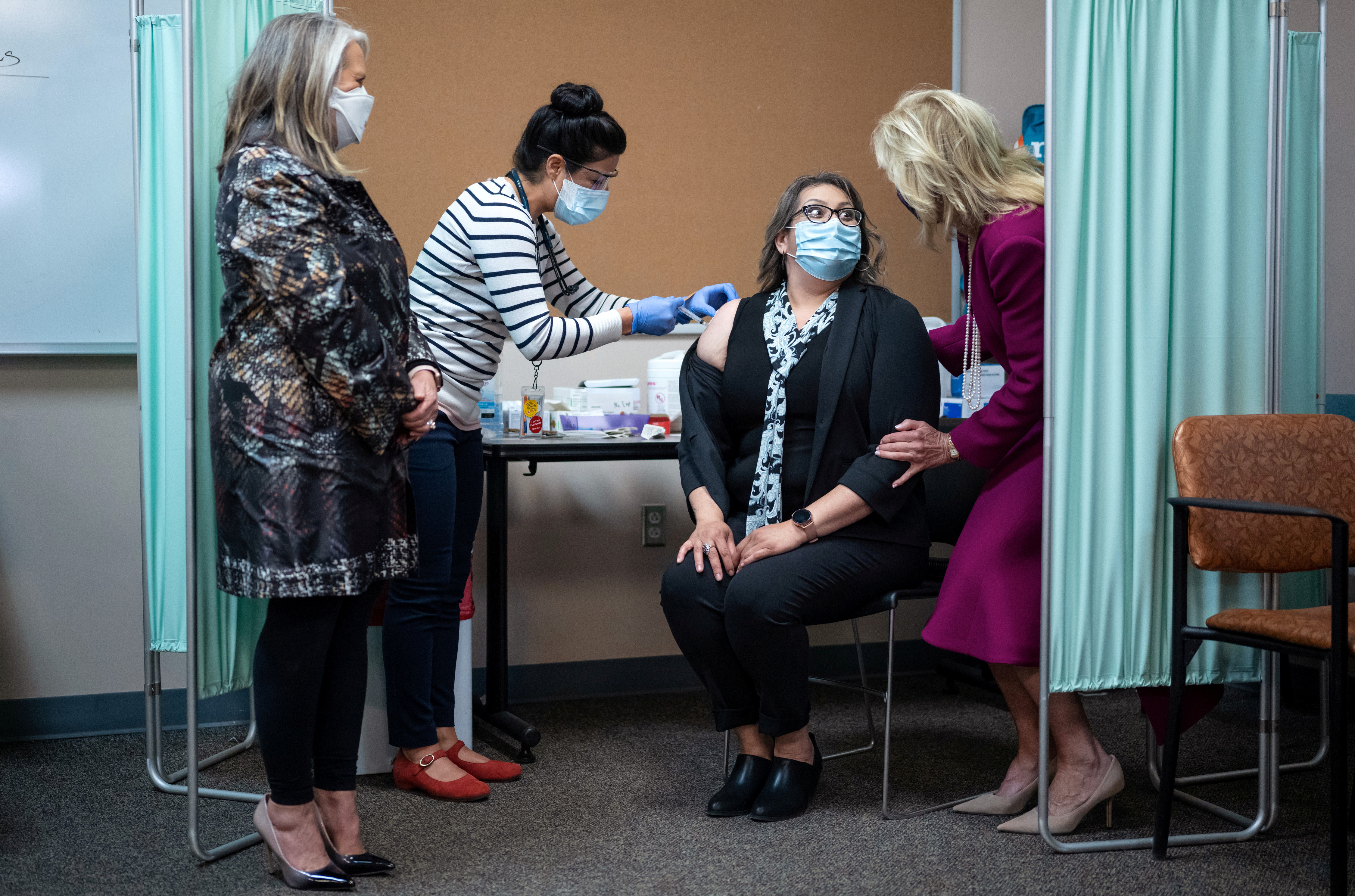 La primera dama Jill Biden le habla a una mujer que está siendo vacunada contra el covid en un centro de vacunación en Albuquerque, Nuevo Mexico. A su izquierda, la gobernadora Michelle Lujan Grisham. (Mandel Ngan/Pool via REUTERS)