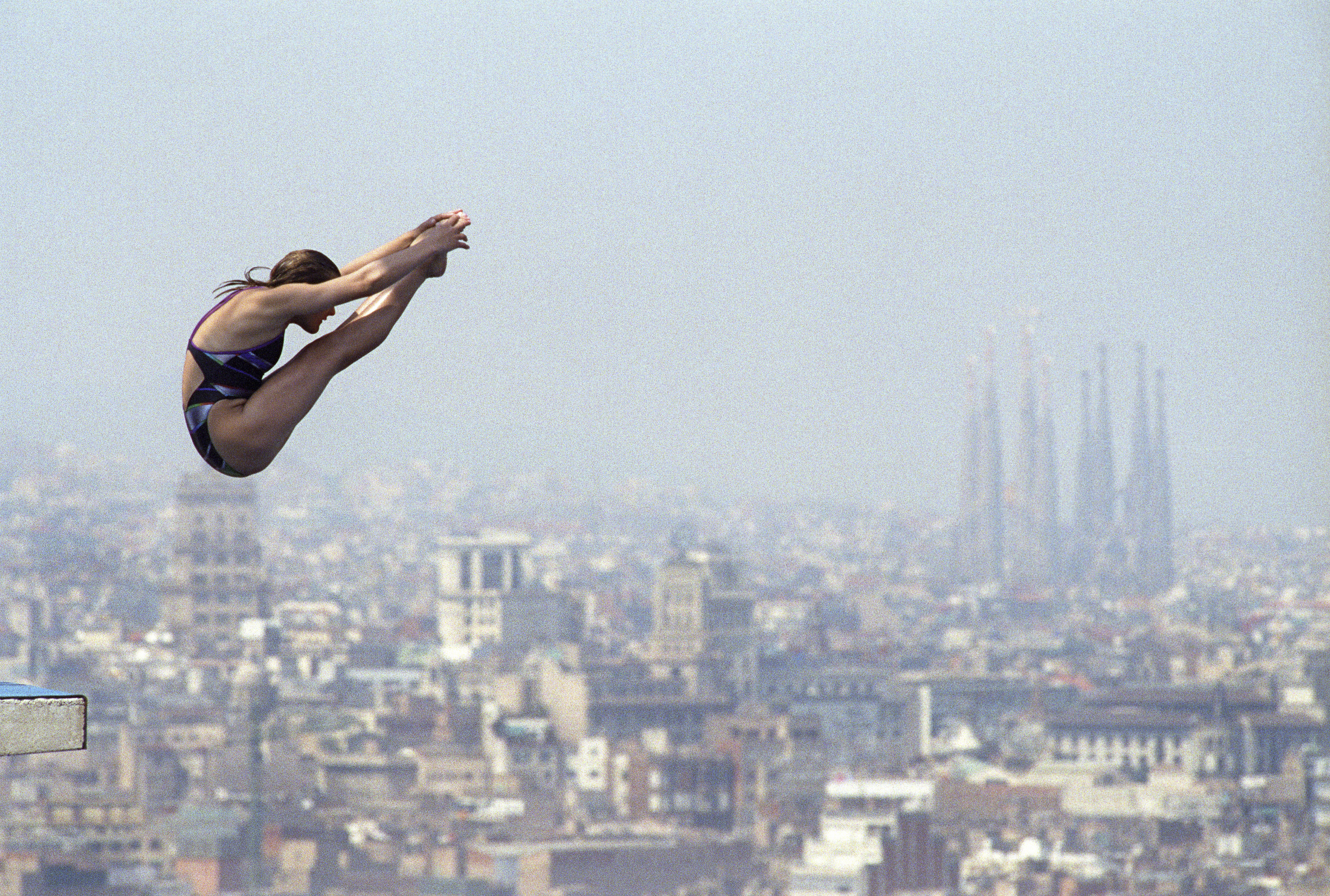 A trampoline jumper during the 10-meter diving event at the 1992 Barcelona Olympic Games. In the background, the city of Barcelona and the temple of the Sagrada Familia. EFE/Txema Fernandez/File