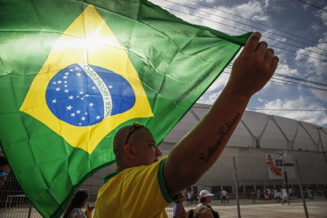 A man holds a Brazilian national flag outside the Arena Amazonia before its inauguration match between Nacional and Remo, in Manaus, Amazonas, on March 9, 2014. The Arena Amazonia is one of the stadiums for the FIFA World Cup Brazil 2014. AFP PHOTO / RAPHAEL ALVES        (Photo credit should read RAPHAEL ALVES/AFP/Getty Images)