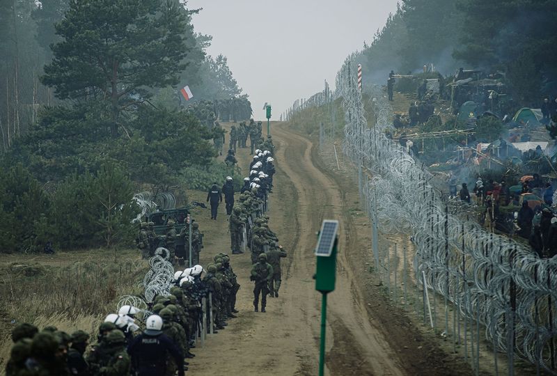 Soldados y policías polacos permanecen de guardia en la frontera entre Polonia y Bielorrusia, cerca de Kuznica, Polonia, en esta fotografía difundida por las Fuerzas de Defensa Territorial, el 12 de noviembre de 2021. Fotografía tomada el 11 de noviembre de 2021. Irek Dorozanski/DWOT/Handout via REUTERS/Archivo