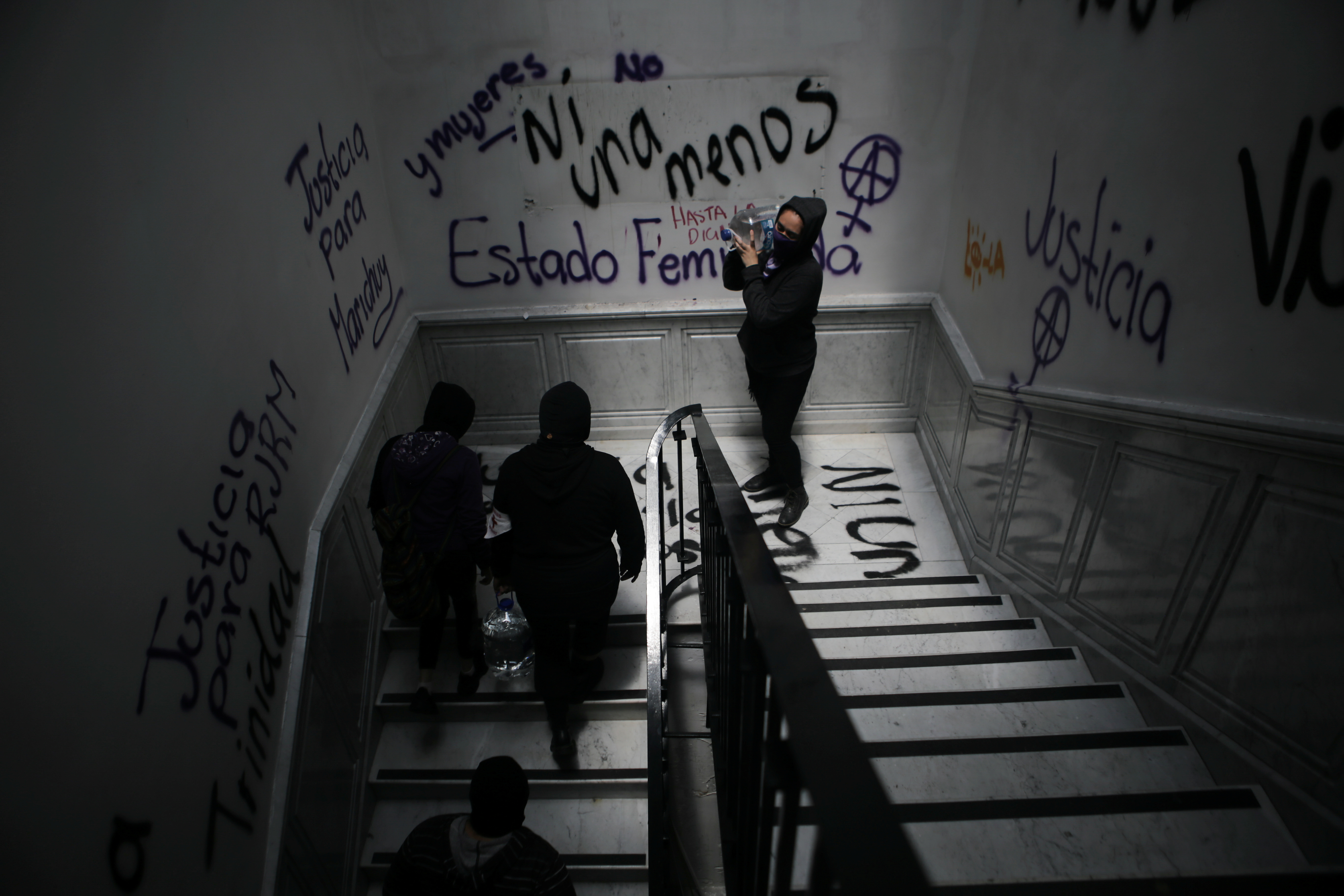 Integrantes de un colectivo feminista cargan bidones de agua mientras toman las instalaciones del edificio de la Comisión Nacional de Derechos Humanos, en apoyo a las víctimas de violencia de género, en la Ciudad de México, México, 11 de septiembre de 2020. Fotografía tomada el 11 de septiembre de 2020.